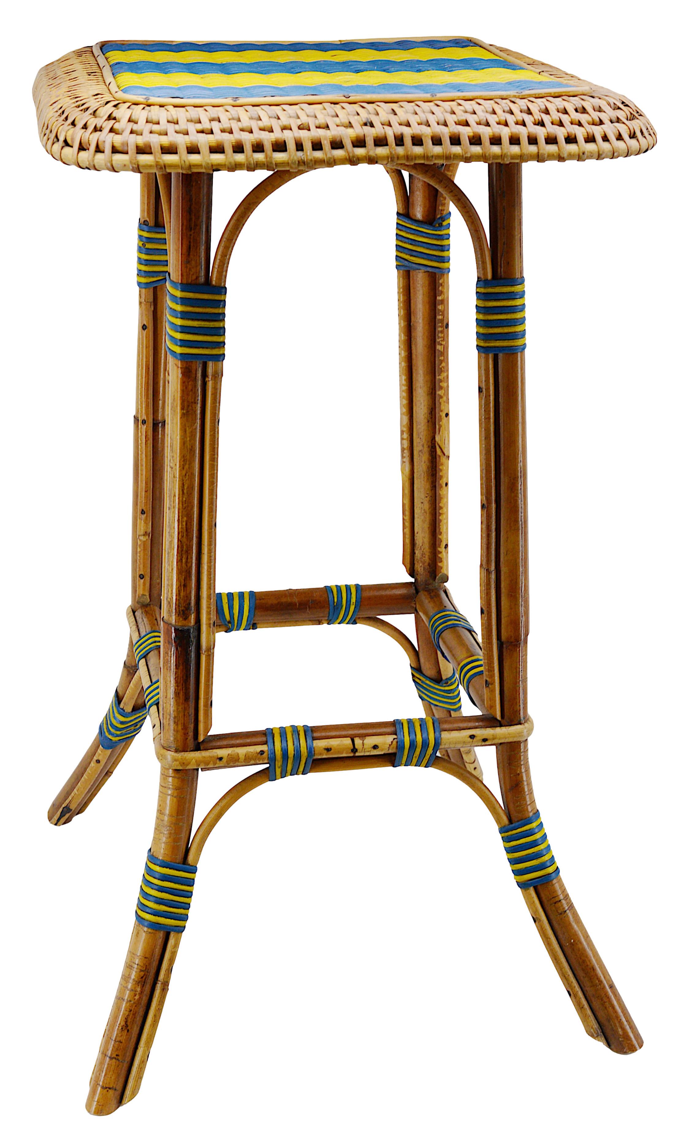 Cette charmante table basse en bambou et rotin, fabriquée en France au début du XXe siècle, témoigne de l'élégance de l'artisanat de l'époque. Avec une combinaison frappante de touches bleues et jaunes, il ajoute une touche de couleur et de chaleur