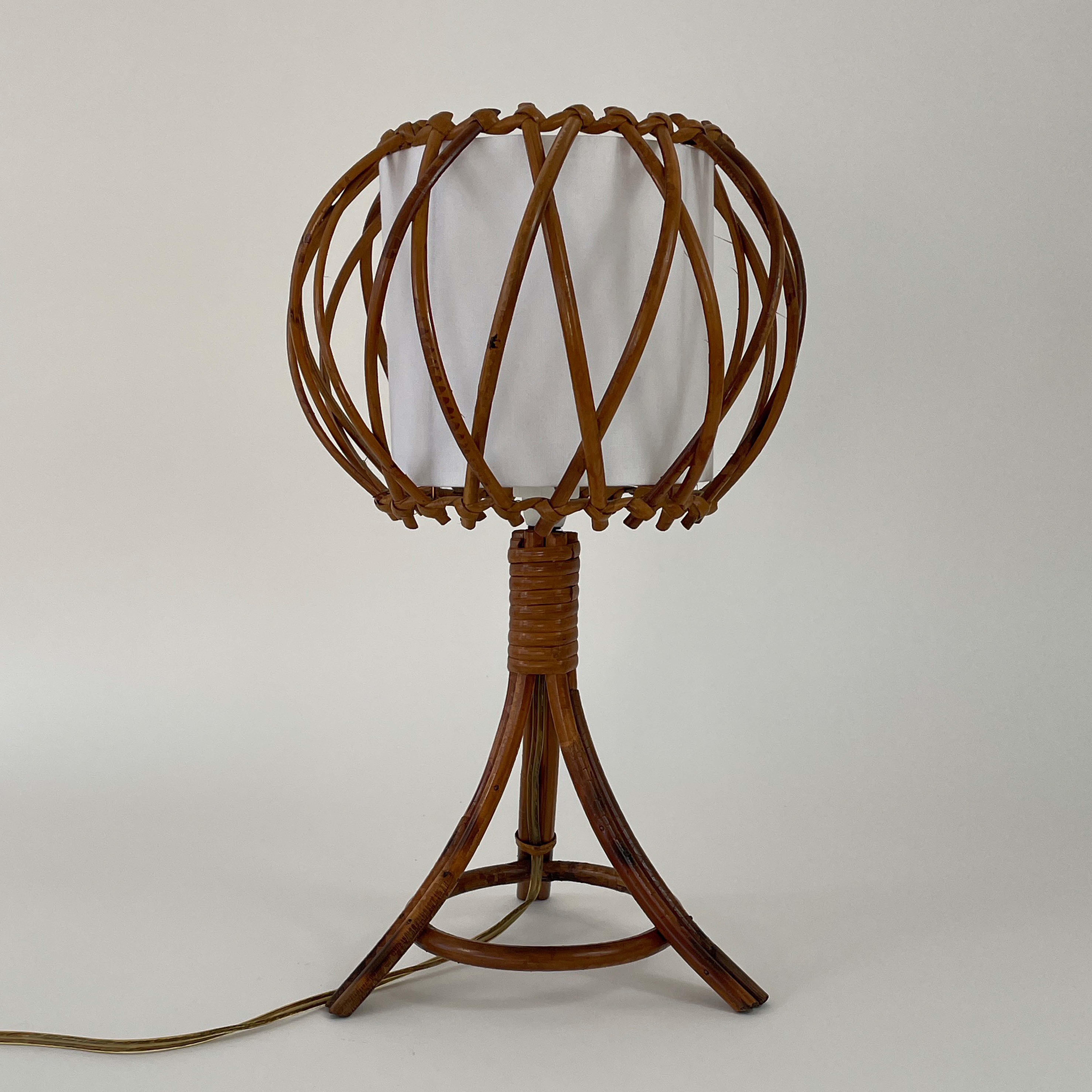 Diese schöne Tischleuchte wurde in den 1950er Jahren von Louis Sognot in Frankreich entworfen und hergestellt. Der Sockel besteht aus Bambus und Rattan, der Diffusor aus cremefarbenem Stoff. Der Lampenschirm aus Stoff wurde überarbeitet.

Die