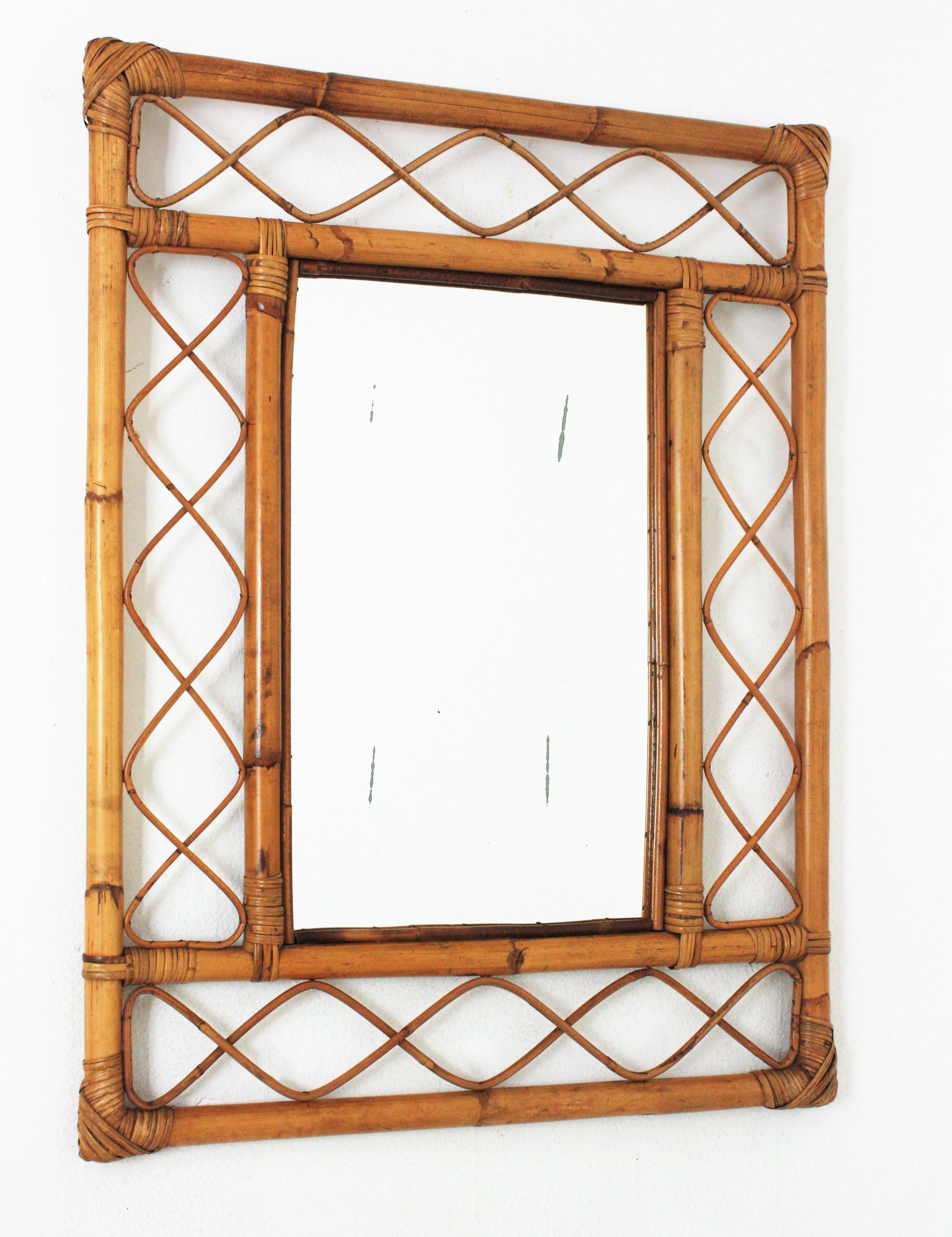 Eye-catching Mid-Century Modern Franco Albini style handcrafted bamboo and rattan mirror. Italy, 1960s.
This mirror features a double bamboo rectangular frame with decorative rattan undulations between the bamboo canes.
This bamboo mirror will be a