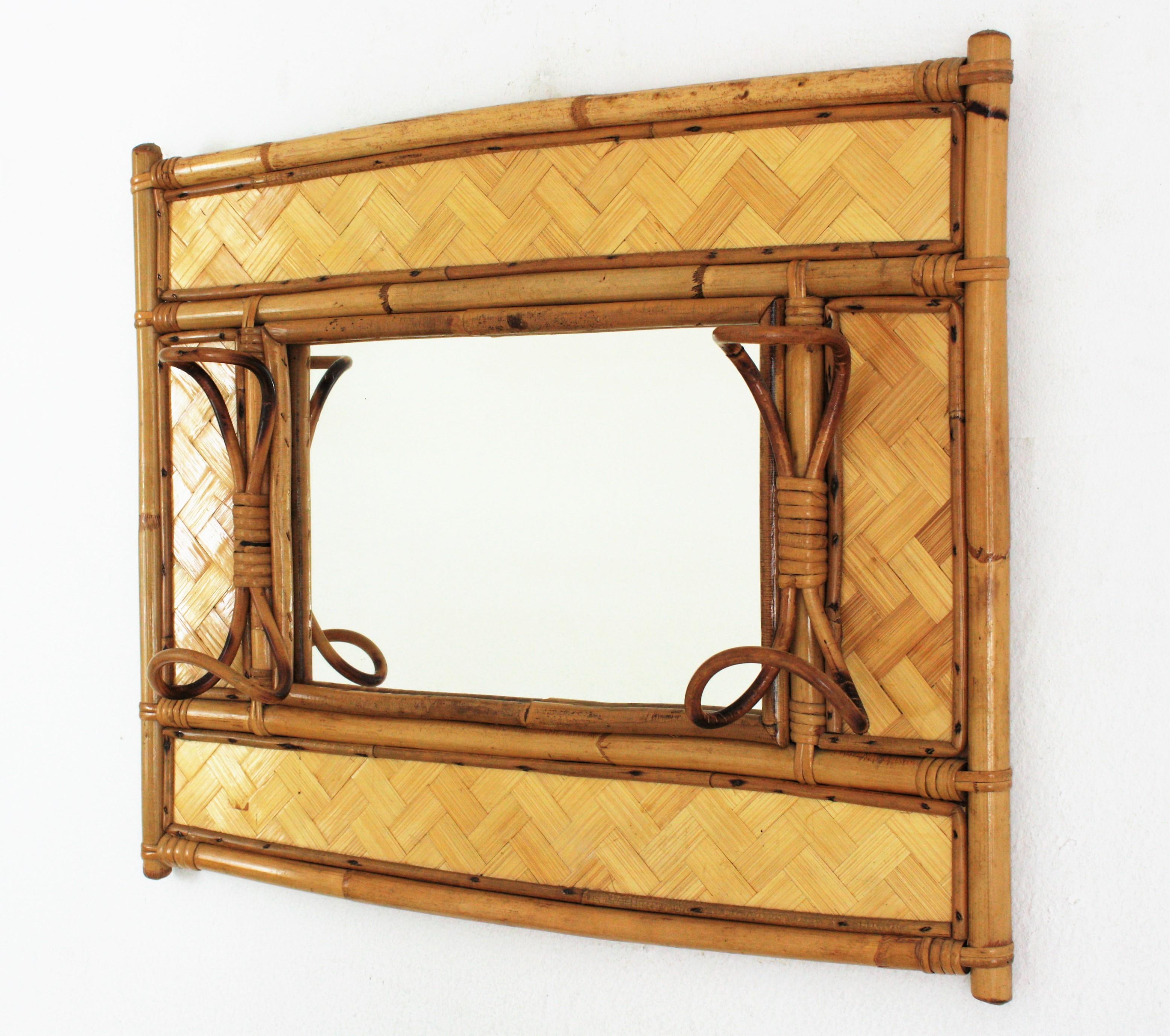Eye-catching rectangular rattan and bamboo mirror / wall coat rack. Italy, 1960s
This handcrafted mirror was designed in the style of Franco Albini.
It has a cool design with a bamboo structure accented by woven rattan details and two hooks at