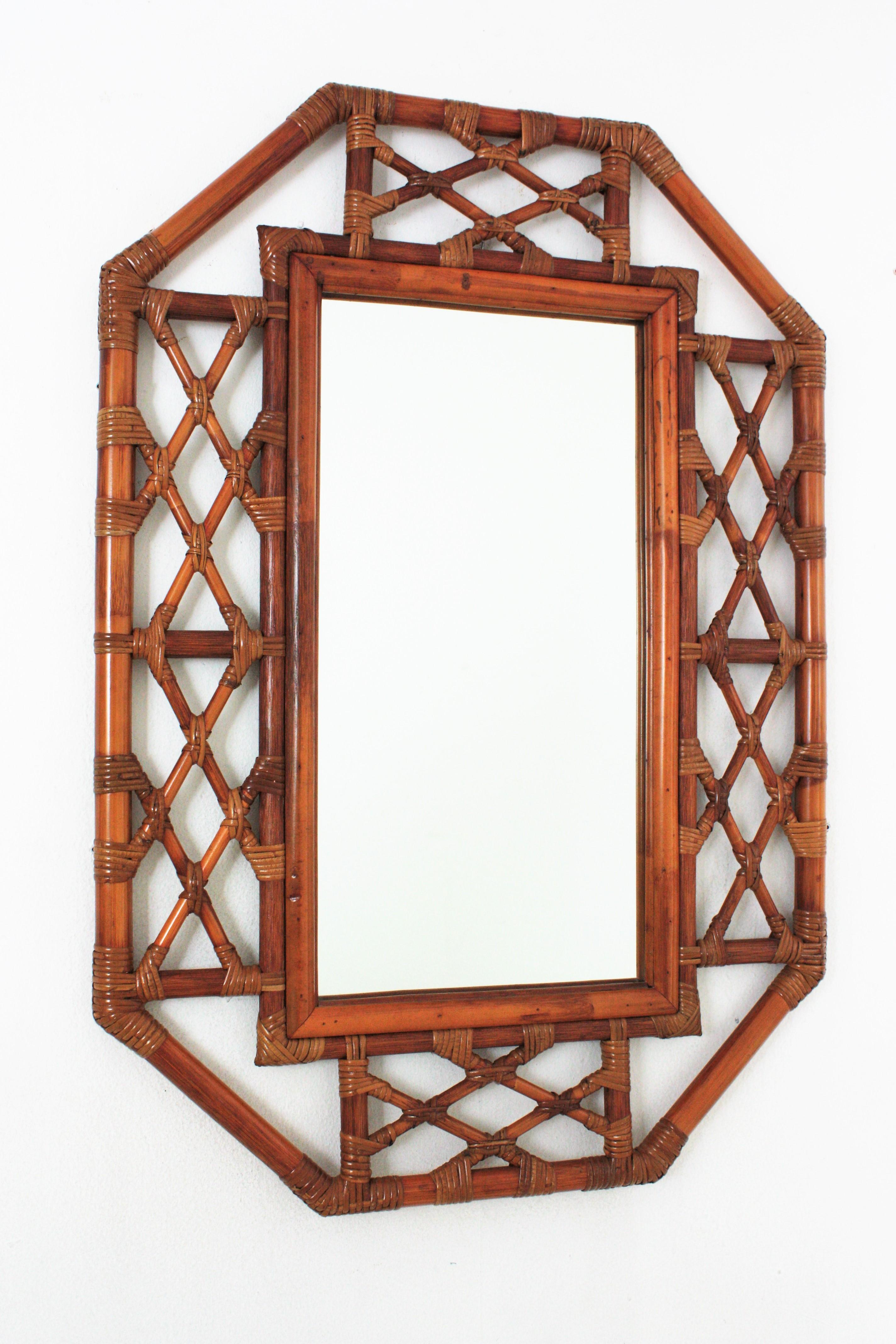 Spanish Mid-Century Modern Bamboo Chinoiserie Tiki style octagonal wall mirror. Spain, 1960s.
Gorgeous oriental inspired mirror handcrafted with bamboo and rattqan canes. It has a highly decorative frame with an intrincate of rattan decorations and