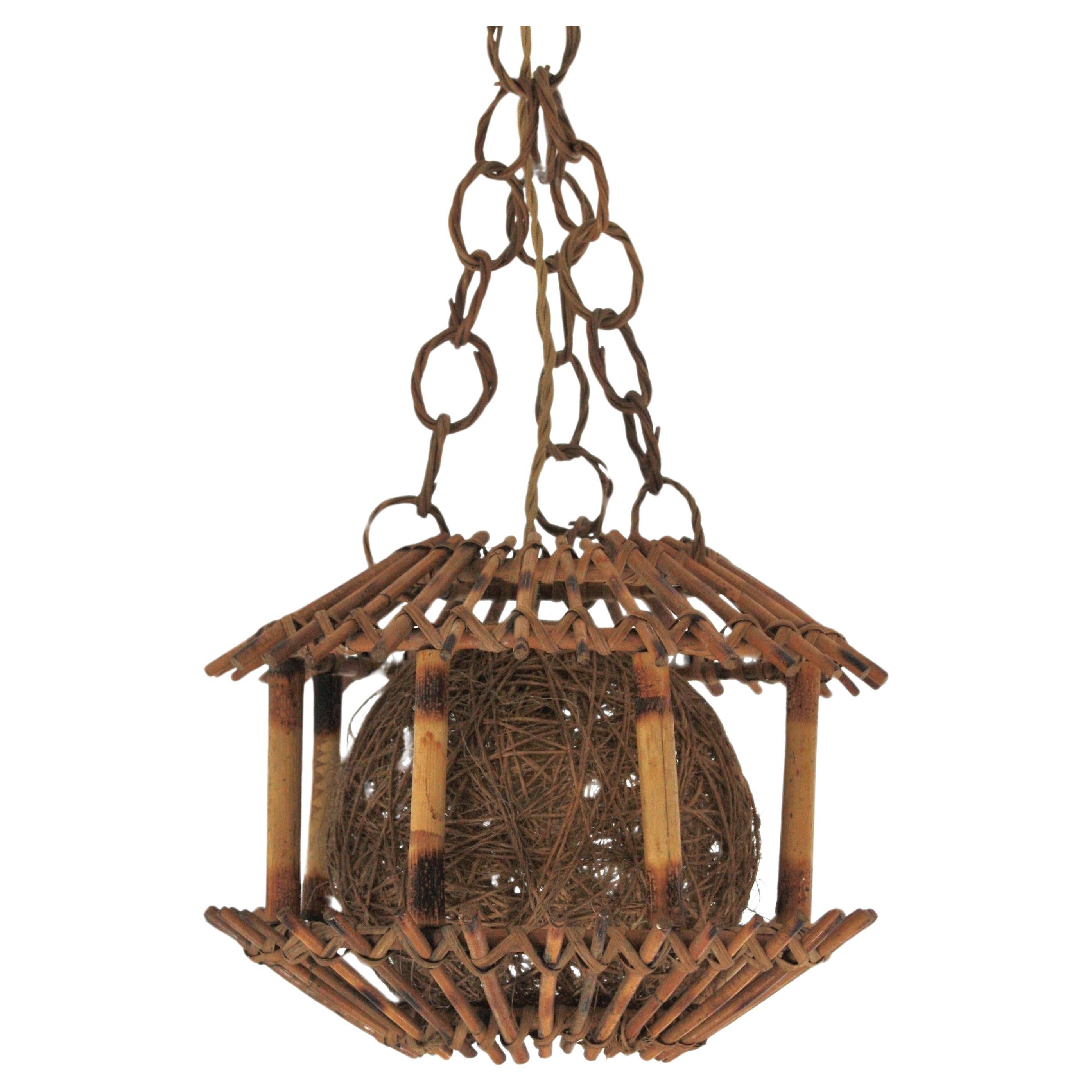 Lampe suspendue moderniste espagnole en bambou et rotin Abat-jour en corde tressée, Espagne, années 1950.
Une trouvaille rare.
Forme de pagode.
Cette lampe sculpturale d'inspiration orientale est suspendue à une chaîne en rotin et sa lumière est