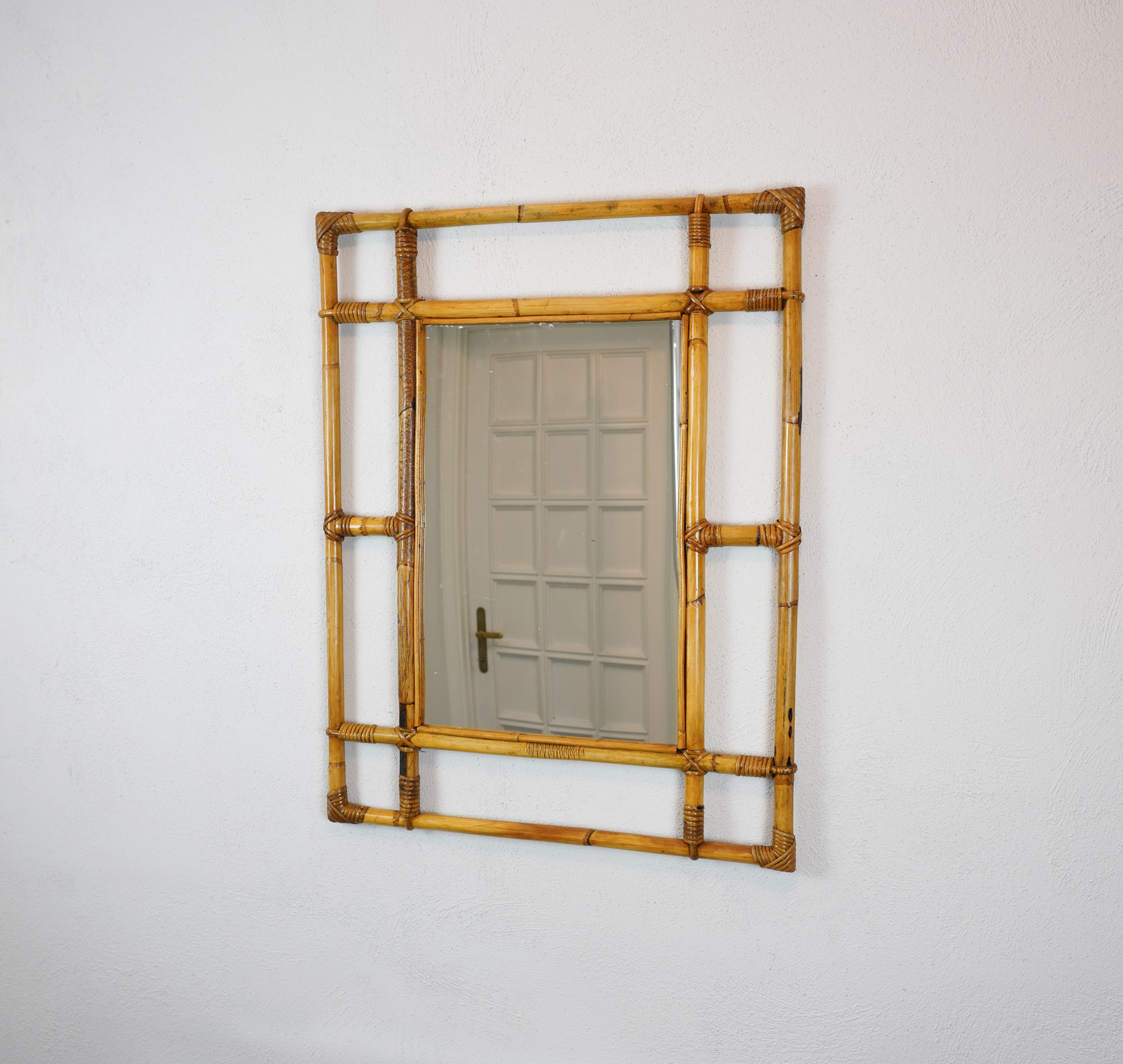 Marvellous wall mirror in bamboo and rattan. 

This item was produced in Italy during the central part of the 1960s. 

An incredible and iconic mirror that will add deepness, elegance and charm to a midcentury-style living room.