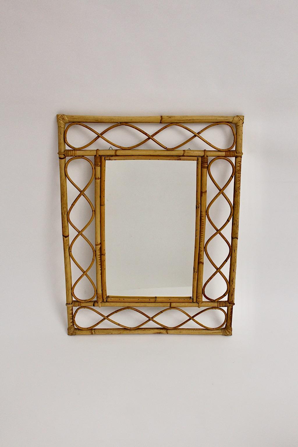 Riviera style organic modern vintage wall mirror or trumeau mirror from rattan / bamboo and mirror glass 1970s France.
Slightly curved loops between bamboo sticks and mirror glass form a lovely wall mirror or trumeau mirror.
The rattan wall