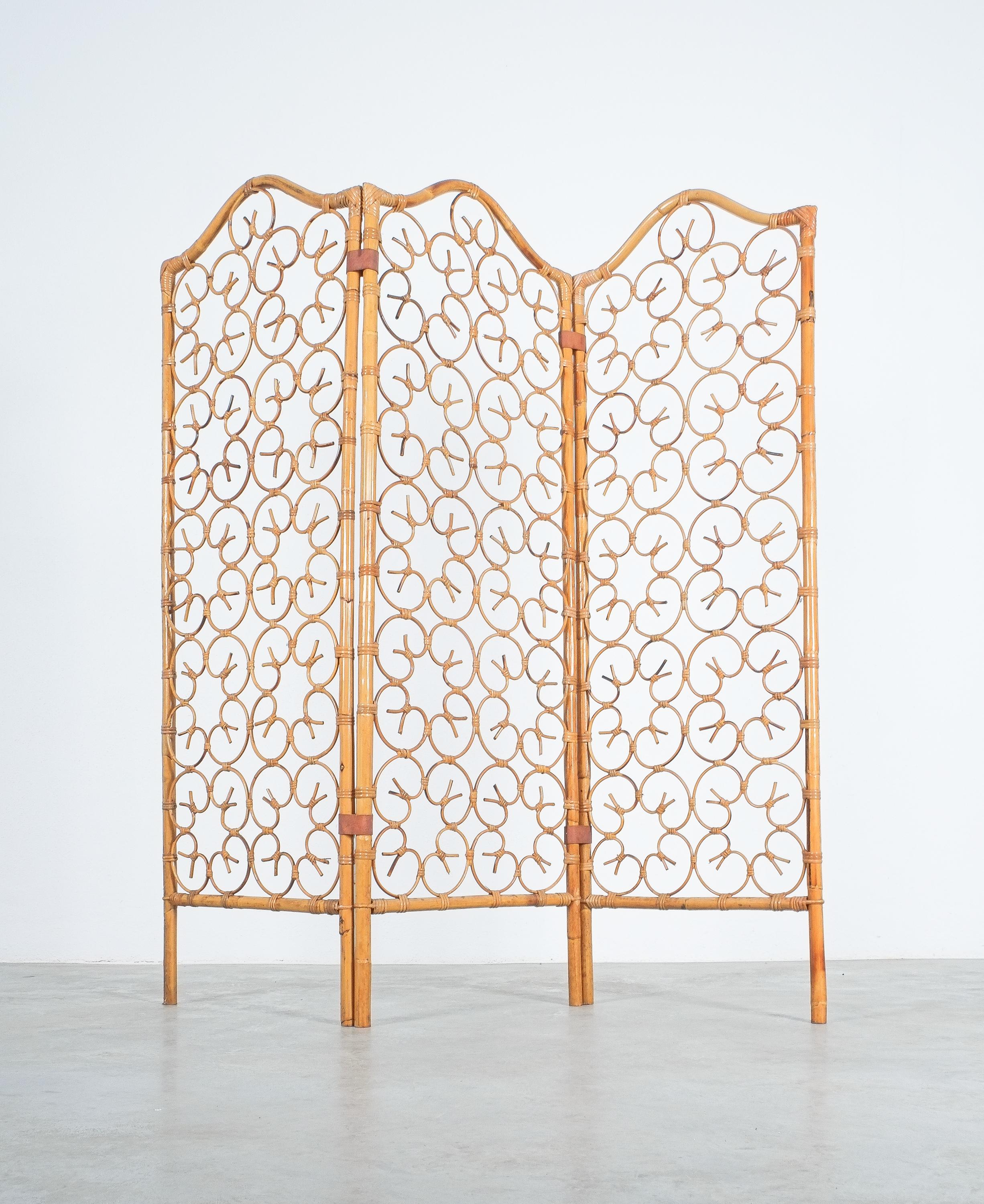Rattan bamboo room divider screen Paravant Italy, circa 1965

Ornamental handmade screen from 3 panels made from bent bamboo and rattan pieces held together with leather 'clamps'. In the grand picture they are form a beautiful large ornament. It's