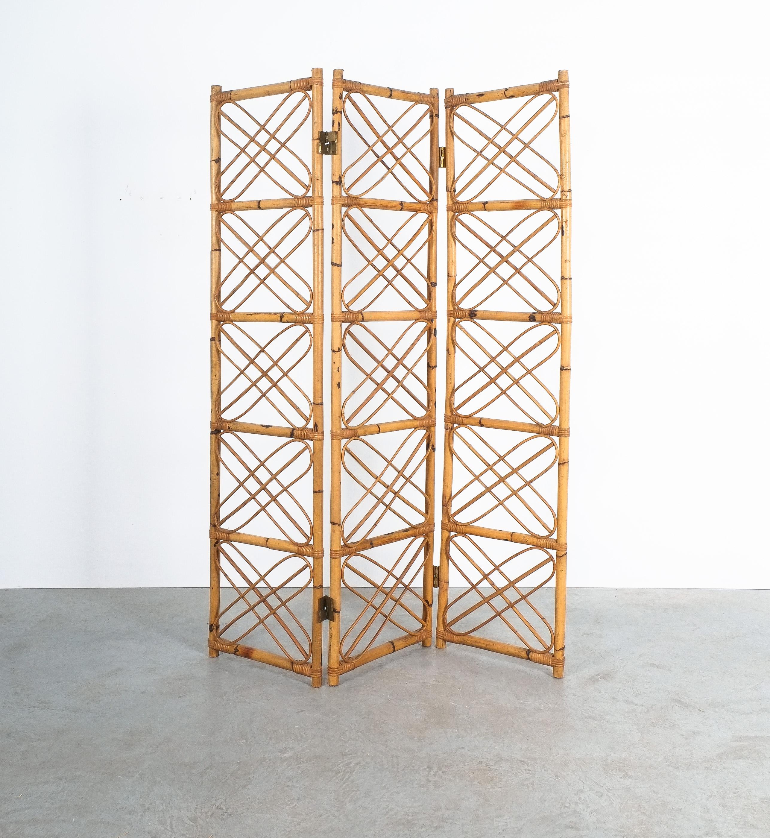 Rattan-Bambus-Raumteiler Paravant Italien, um 1965

Ornamentaler, handgefertigter Paravent aus 3 Paneelen, die aus gebogenen Bambus- und Rattanstücken bestehen und mit Messingscharnieren zusammengehalten werden. In dem großen Bild bilden sie ein