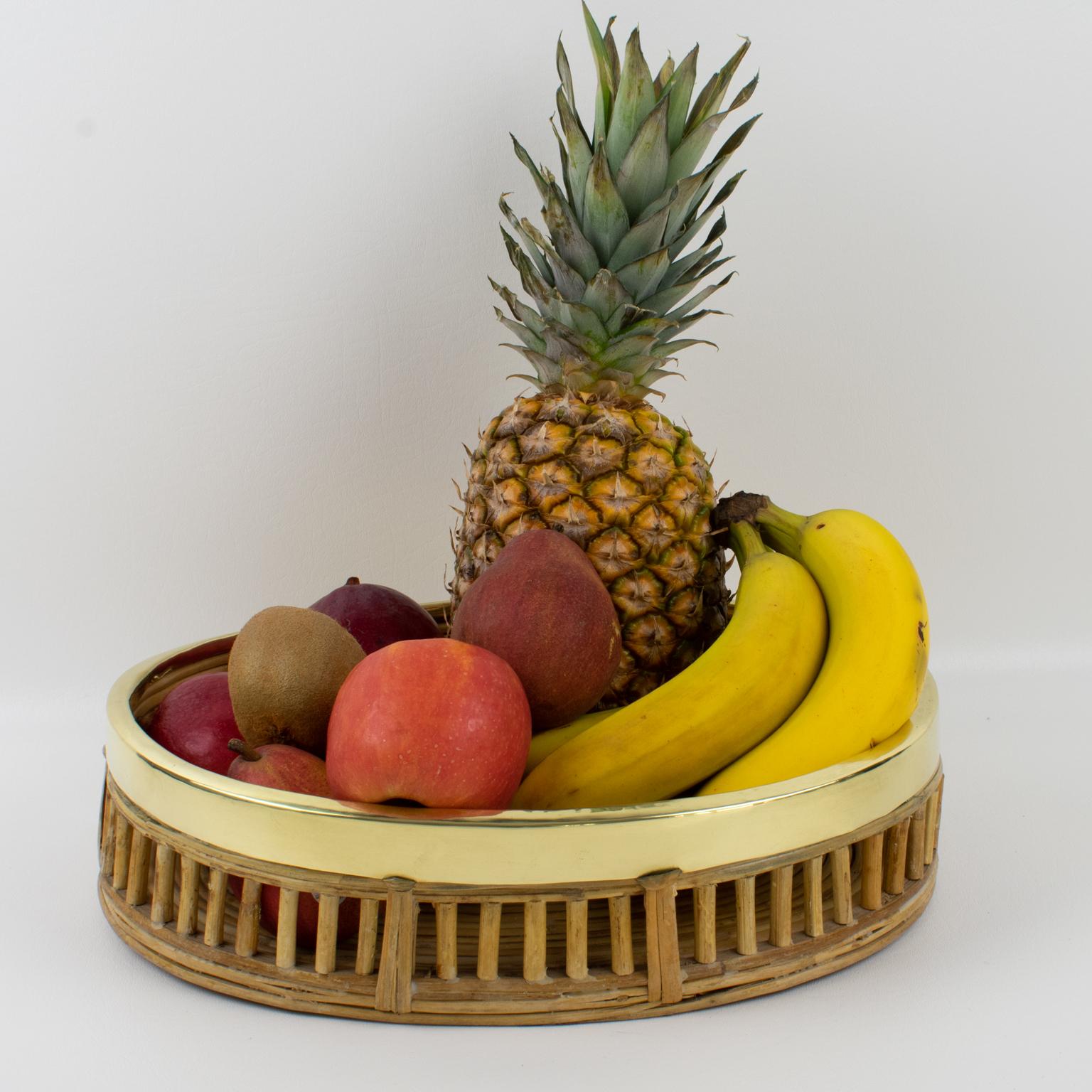 Ce joli centre de table ou bol en bambou, rotin ou osier avec garniture en laiton a été fabriqué vers 1960. Ce panier décoratif de style Modern-Decor a été fabriqué à la main en Italie. La forme ovale a un design transparent et un bord en laiton