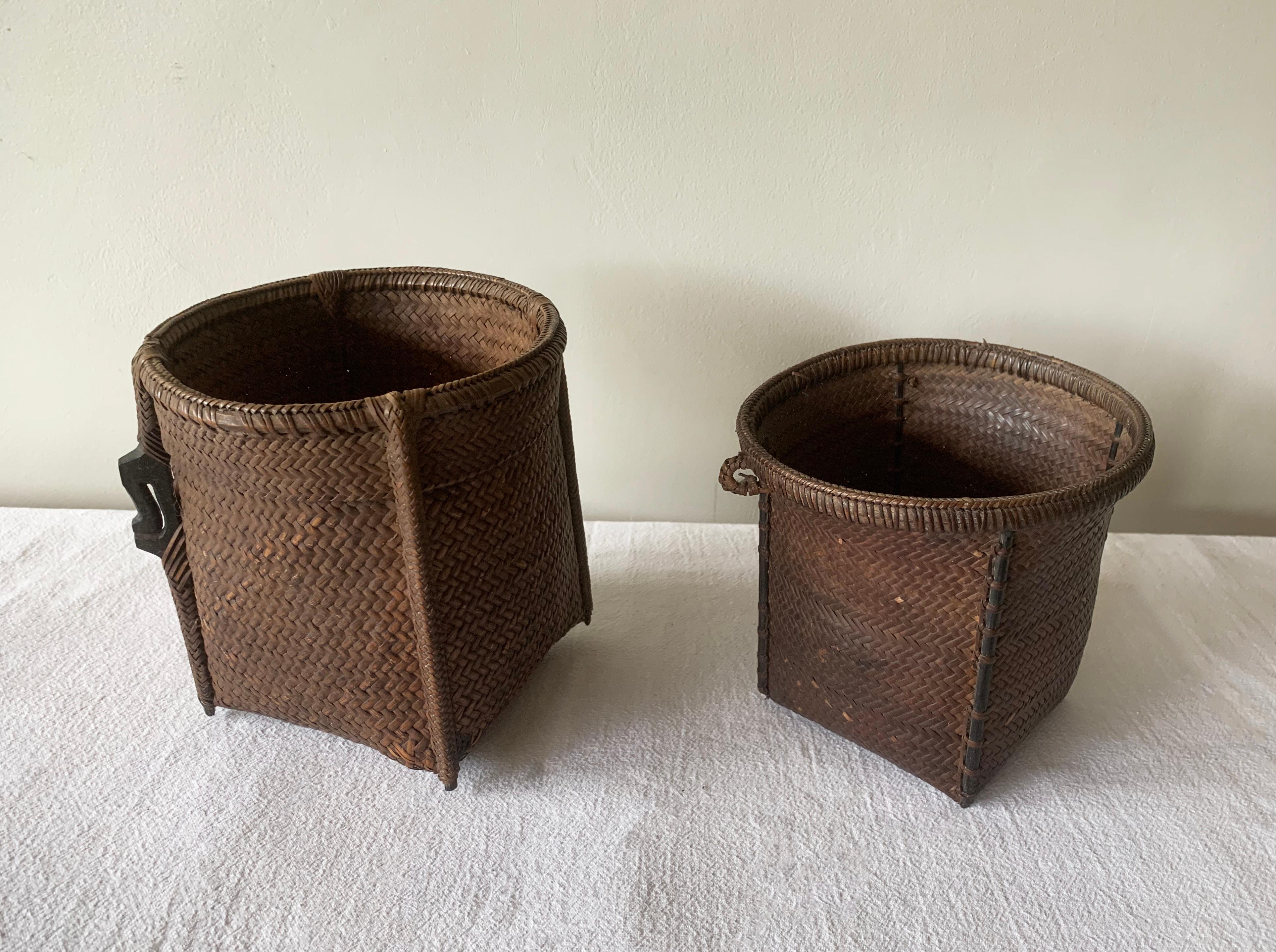 This pair of small mid-20th century hand-woven baskets originate from the Dayak tribe of Borneo. They were crafted with rattan fibres and an iron wood frame. While larger versions of these baskets were used to carry leaves, fruit, grain and wood its