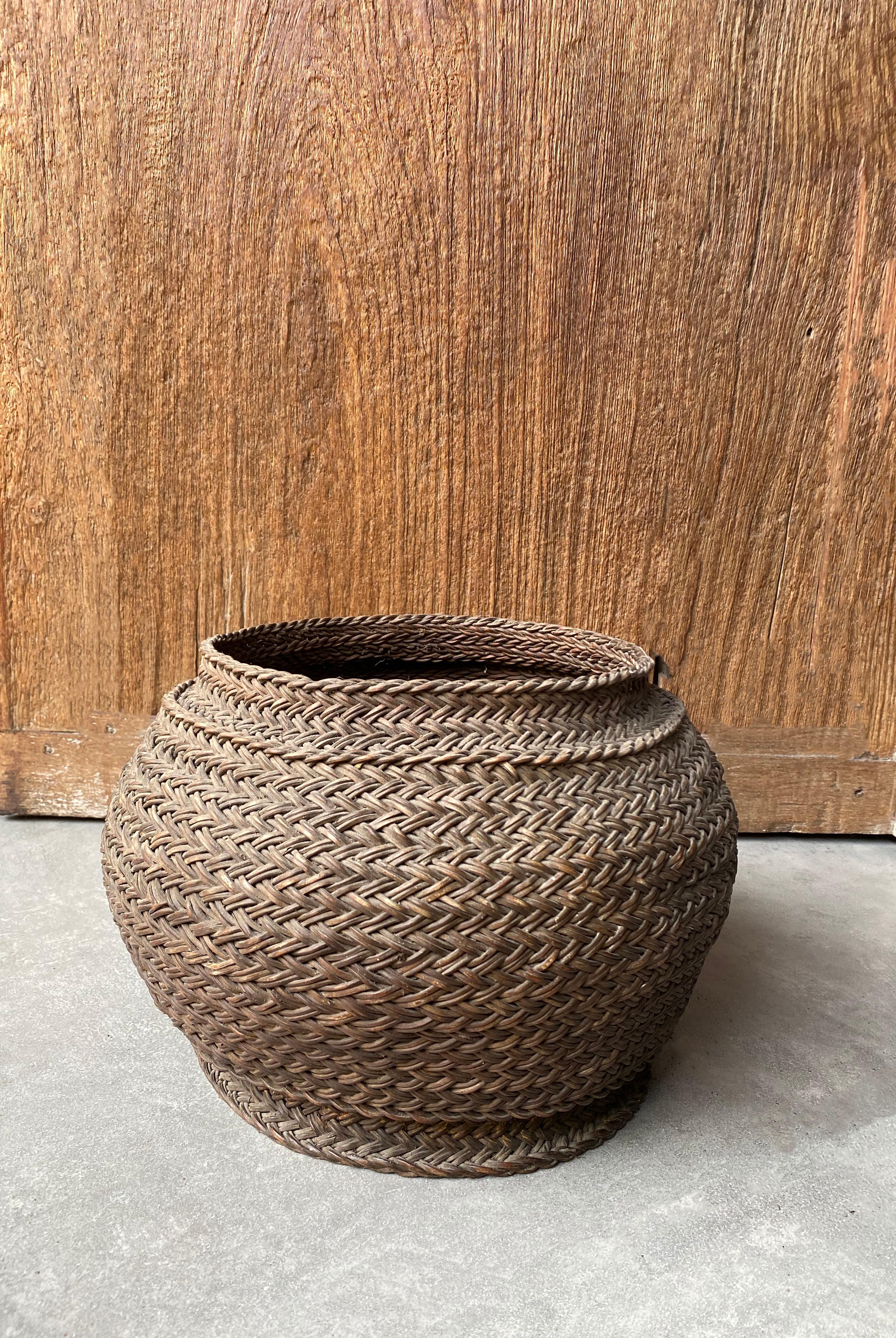 This mid-20th century hand-woven basket originates from Toraja, Sulawesi. It was crafted using elegantly woven plant fibres.

Measures: Height 22cm x diameter 22cm.