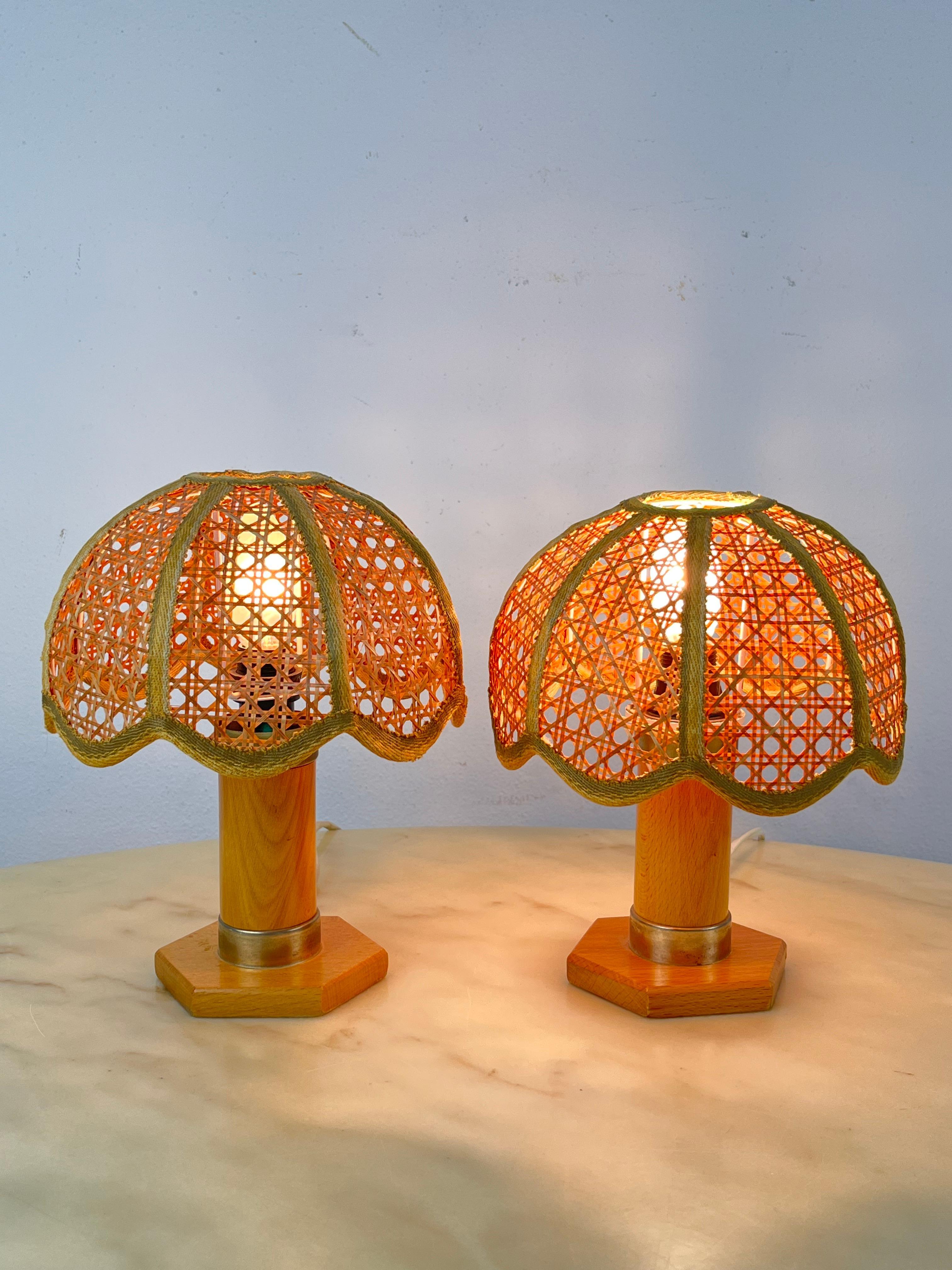 Wonderful pair of mid century wicker and rattan table lamps. These lovely French Riviera style table lamps were designed and made in Italy in the 1960s. Completely handcrafted with perfect proportions, mixing curved rattan, hand-woven Vienna straw