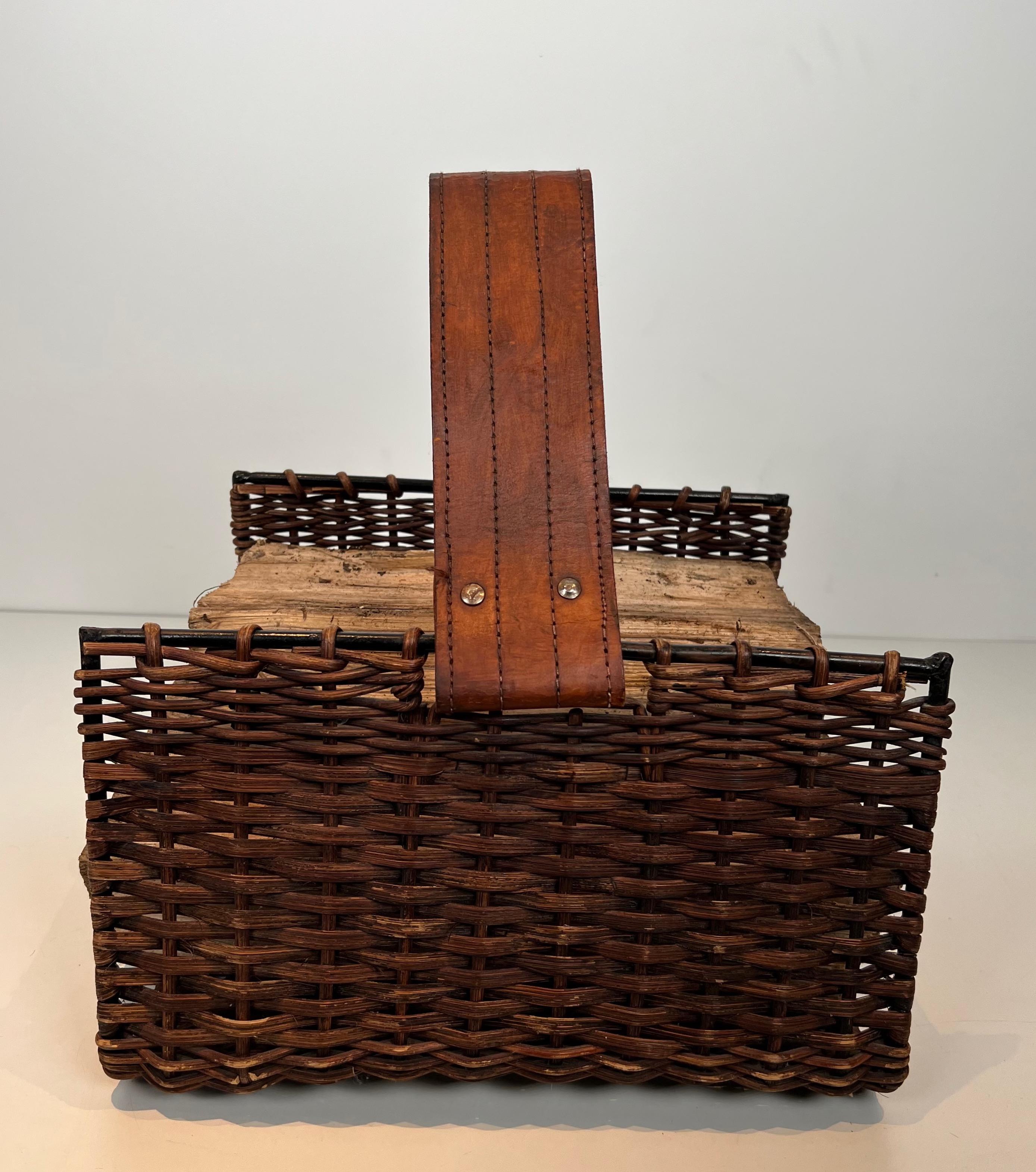 This nice and unusual logs holder is made of rattan, black lacquered metal and leather . This is a French work. Circa 1970