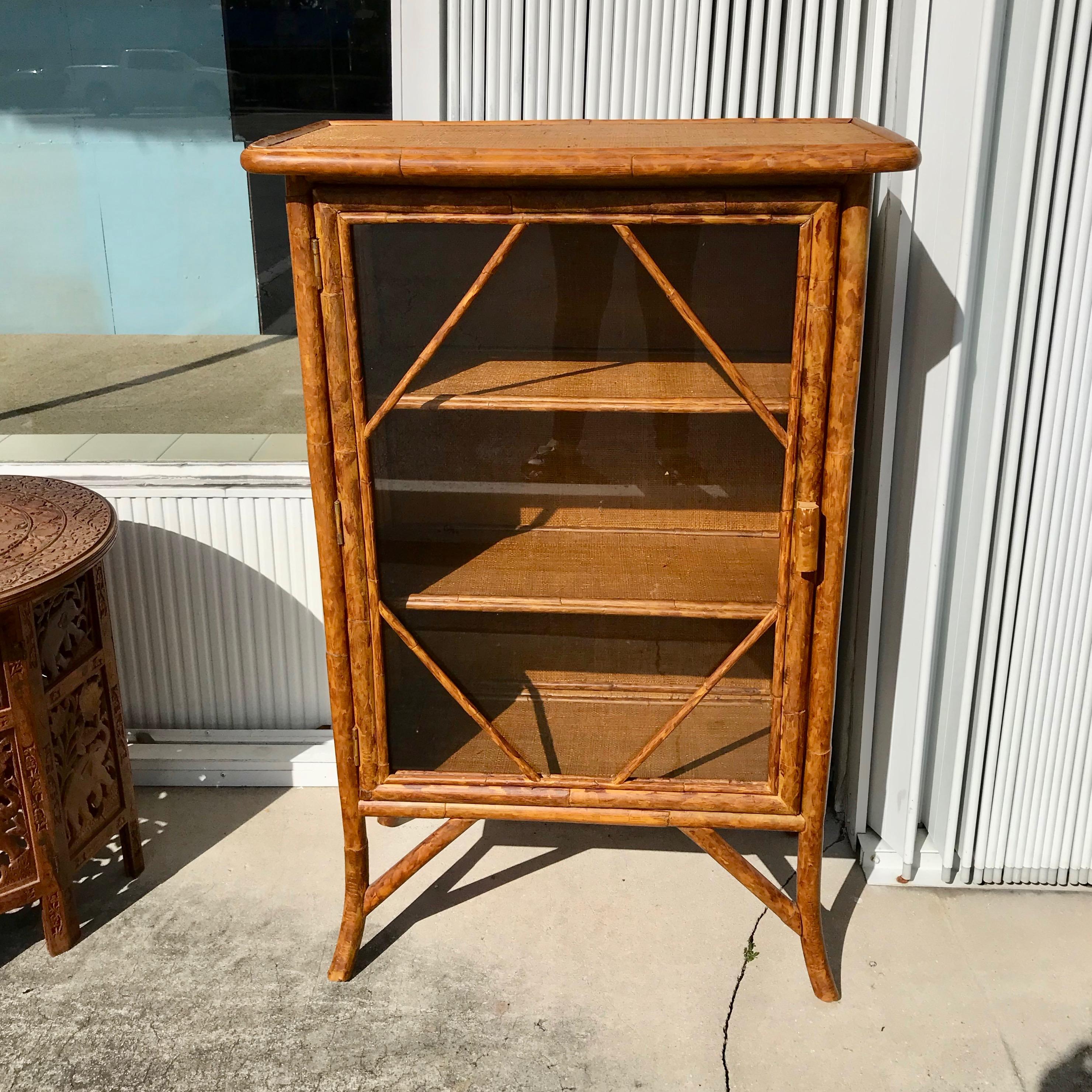 Attractively fashioned with rattan facing on grasscloth covered shelves.
Nicely accented front door. The top and side panels are also covered
with grasscloth.
Nicely proportioned vintage piece.