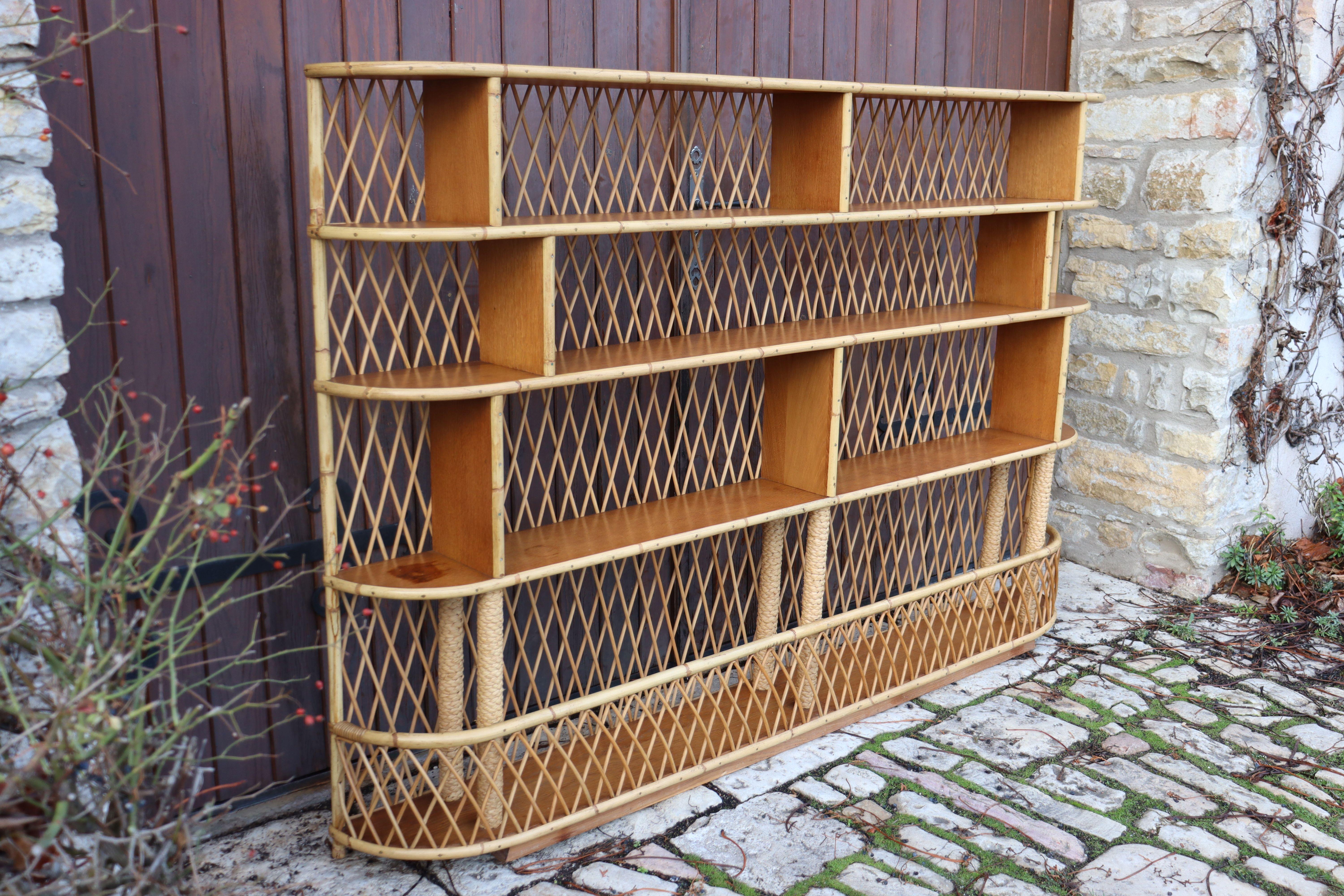 Very large bookcase/shelf on rattan, wood and rope legs. Excellent general condition and beautiful patina of time present. This piece will have its effect.
