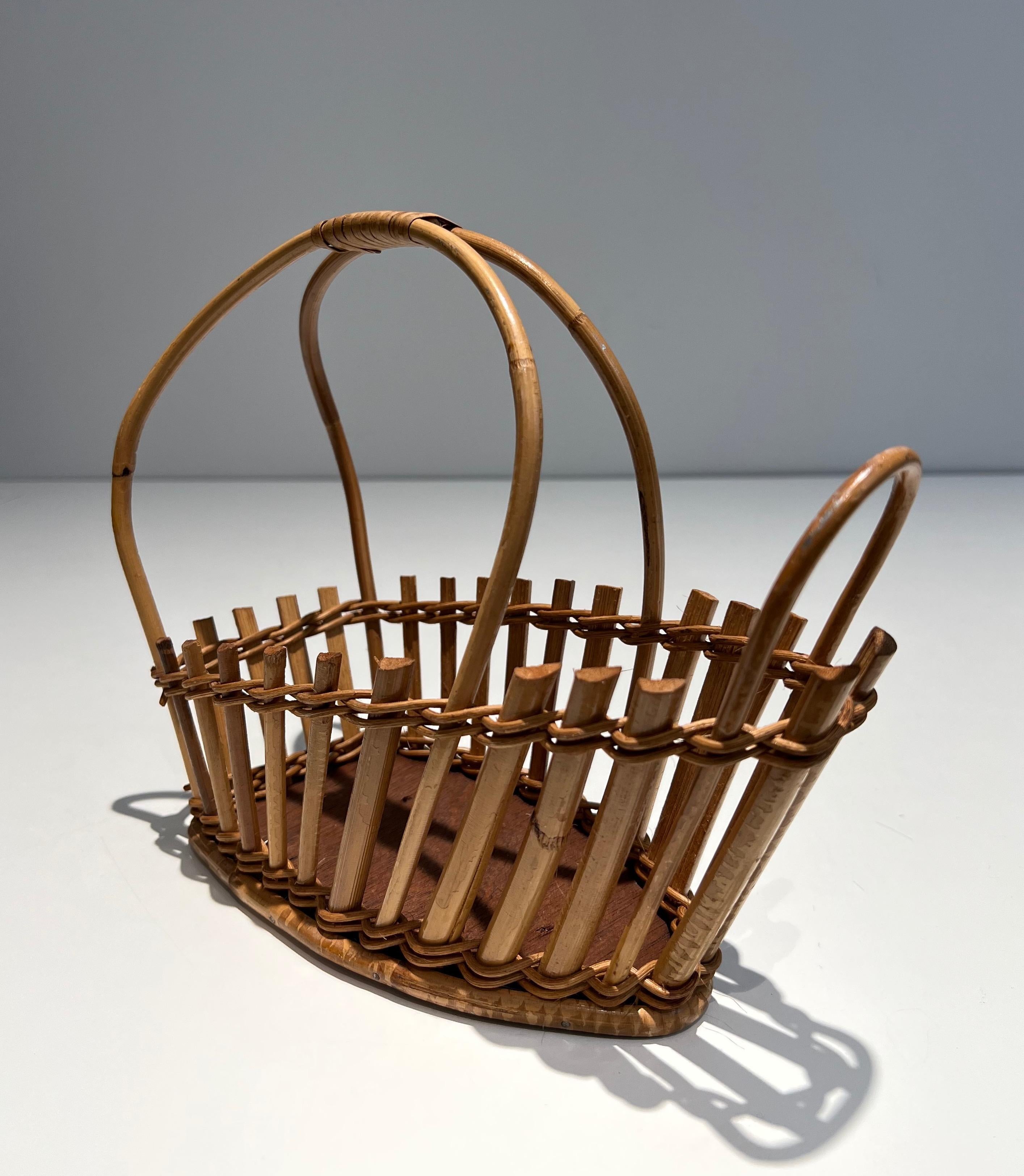 This unusual bottle holder is made of rattan. This is a French work. Circa 1970