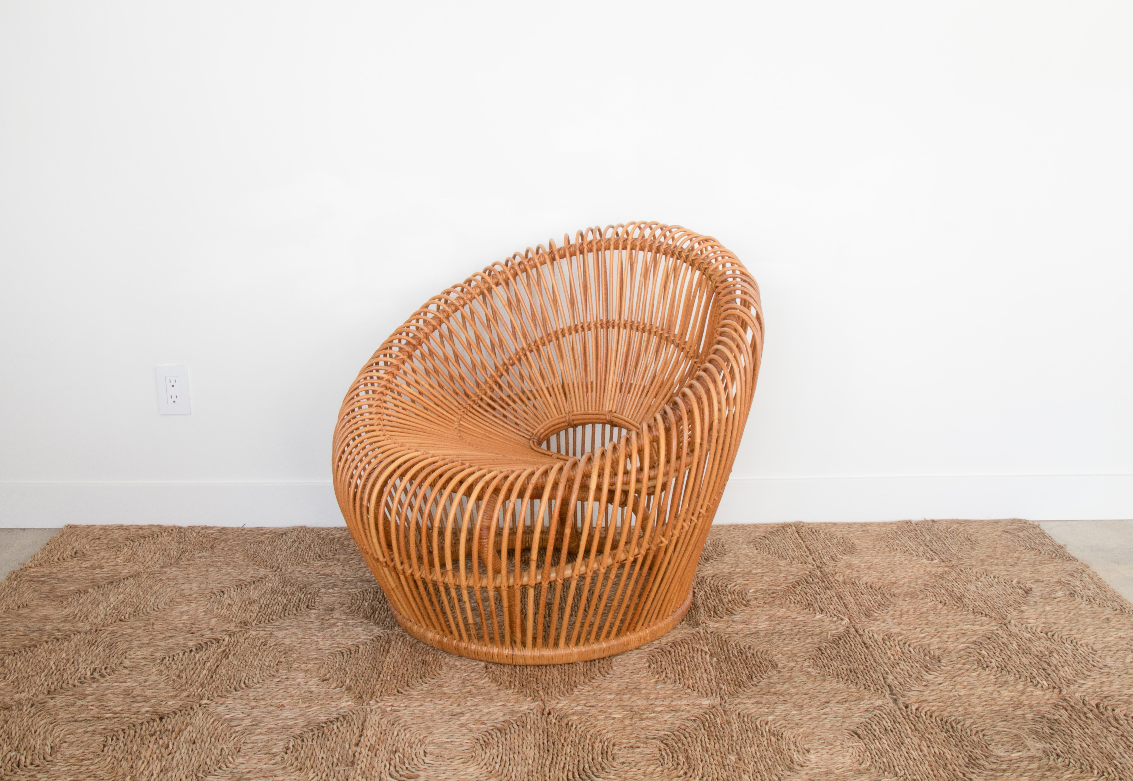 Large rattan bucket chair in the style of Franco Albini. Curved rattan with small open back and deep seat, making the chair very comfortable. Beautiful statement chair. 2nd similar chair also available.