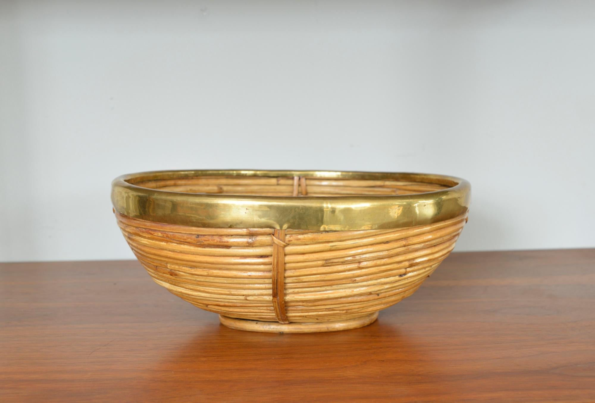 A stunning 1970s Italian oval basket hand-crafted in curved pencil reed, split cane and brass. This delightful decorative object was produced in Italy during the 1970s by Vivai del Sud. The brass has been hand formed around the edge of the rim and