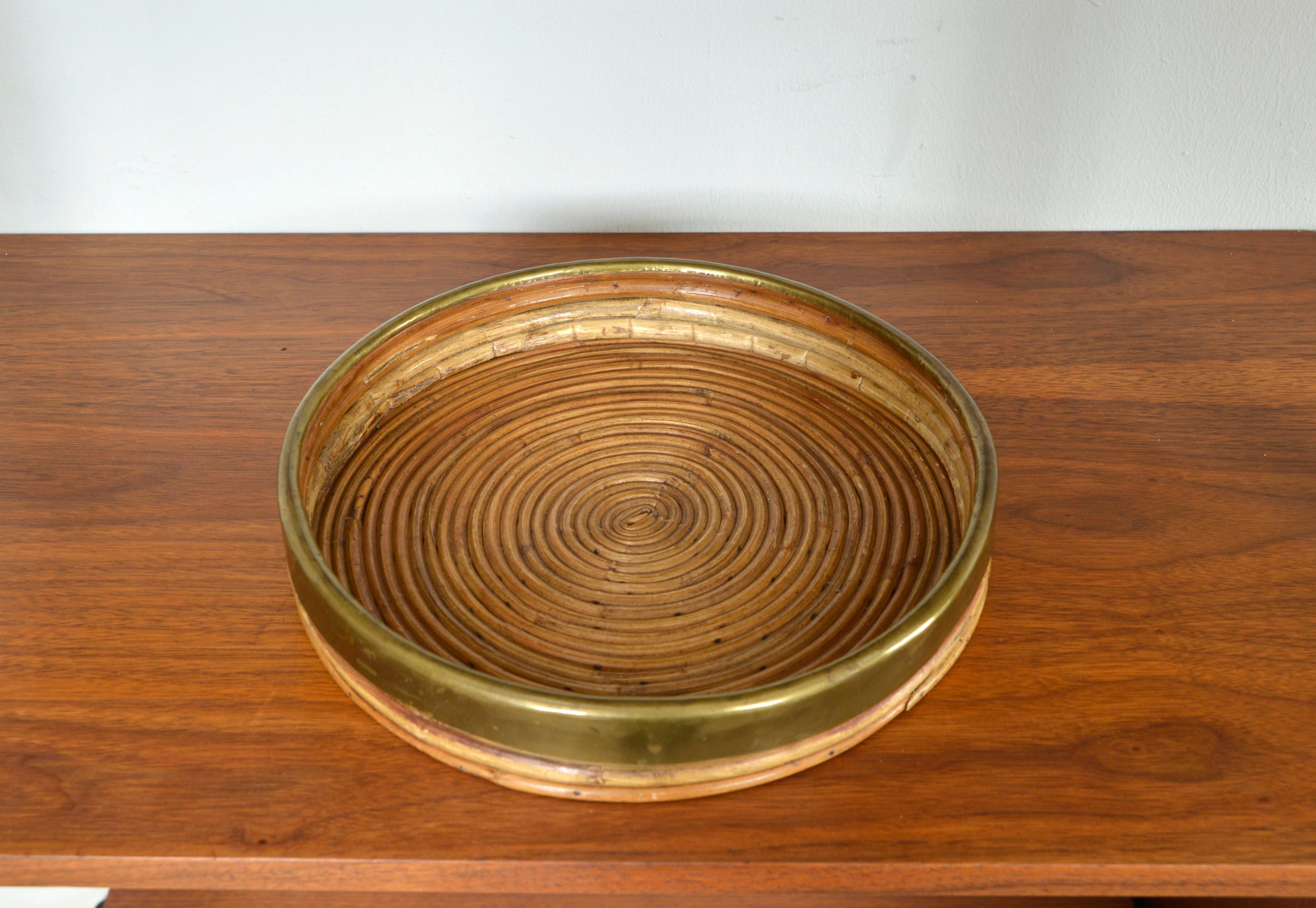 A stunning 1970s Italian tray basket hand-crafted in curved pencil reed, split cane and brass. This delightful decorative object was produced in Italy during the 1970s by Vivai del Sud. The brass has been hand-formed around the edge of the rim and