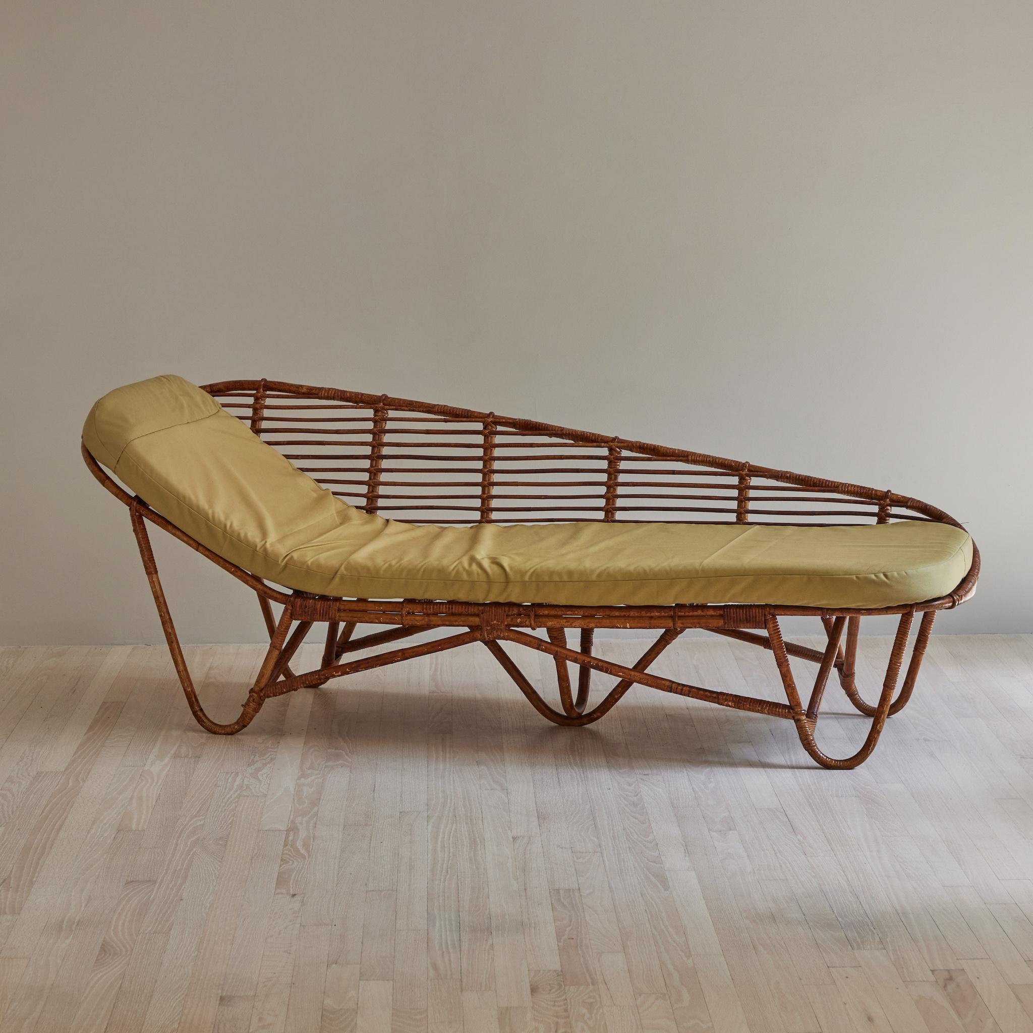 French mid-century rattan daybed, chaise, or loveseat. Warm and relaxed, this piece invites you to kick-back. The simple repetition of lines and soft curves gives this mid-century piece its natural sex appeal.
