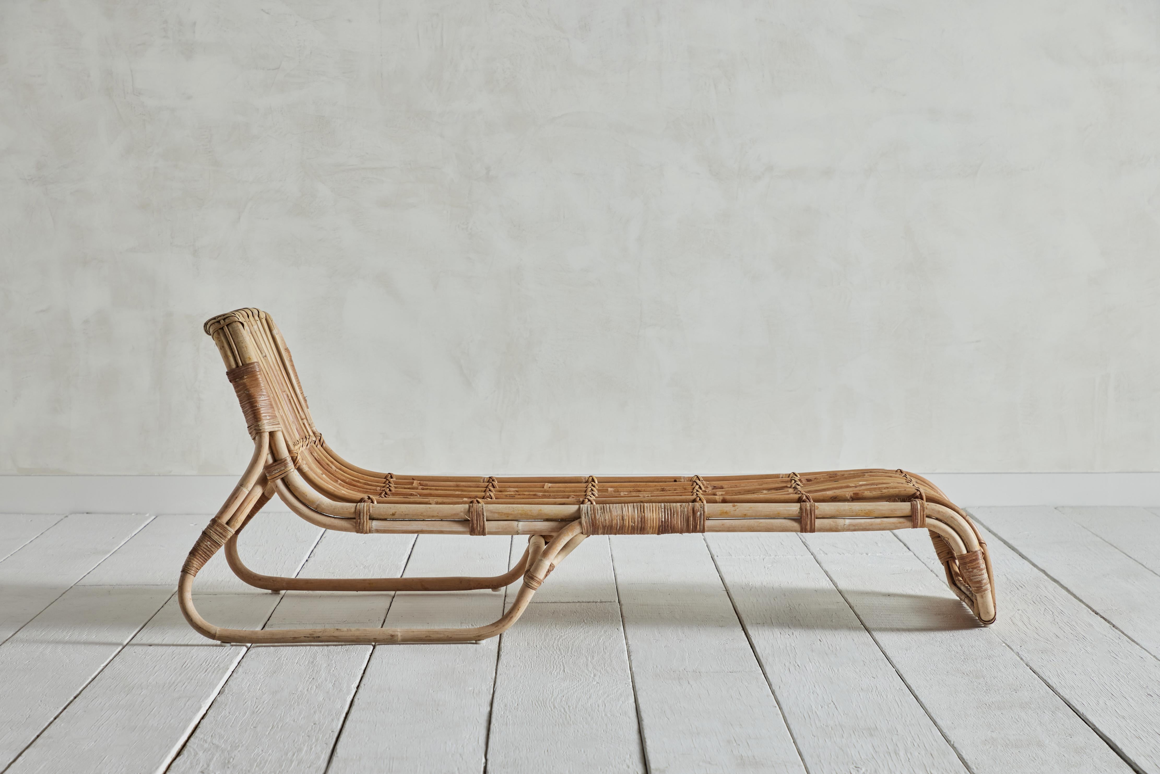 Sedia chaise lounge in rattan proveniente dalla Francia, intorno alla metà del 1960, nello stile di Tito Agnoli. Il rattan e il bambù presentano alcuni segni di usura dovuti all'età e all'uso. 