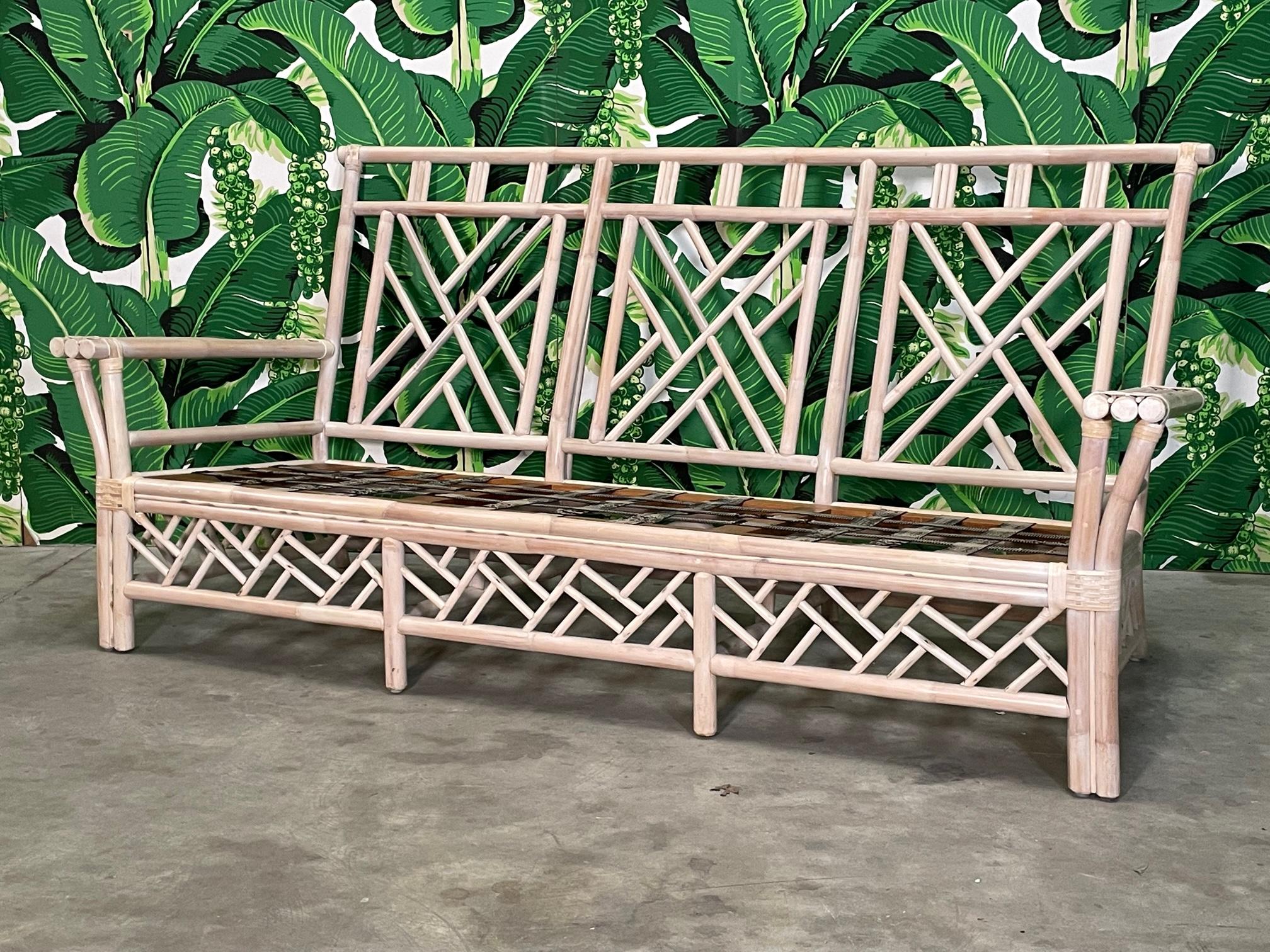 Rattan sofa features fretwork in the Chinese Chippendale style, perfect to complete your chinoiserie look. Good condition with minor imperfections consistent with age. May exhibit scuffs, marks, or wear, see photos for details. Includes seat and