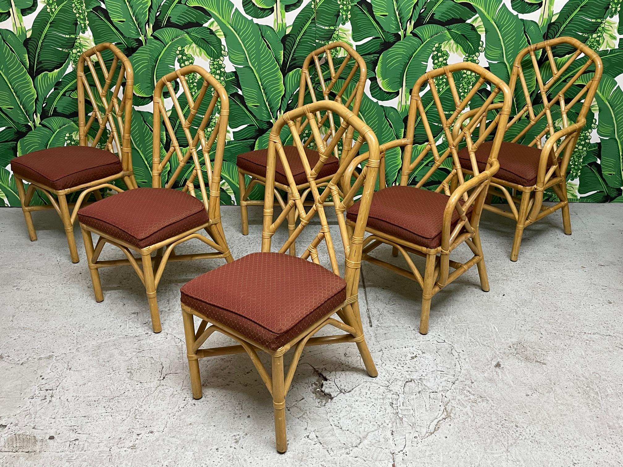 Set of six rattan dining chairs feature Chinese Chippendale style fretwork, splayed rear legs, and cushioned seats. Good vintage condition with minor imperfections consistent with age, see photos for condition details. 
For a shipping quote to your