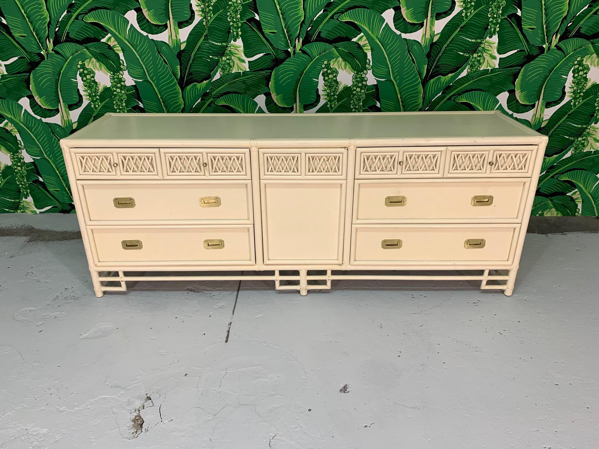 Asian chinoiserie style rattan dresser features lattice pattern drawer fronts and brass hardware. Cream colored finish. Good vintage condition with abrasions and marks to finish, structurally sound condition. Professional refinishing is available,
