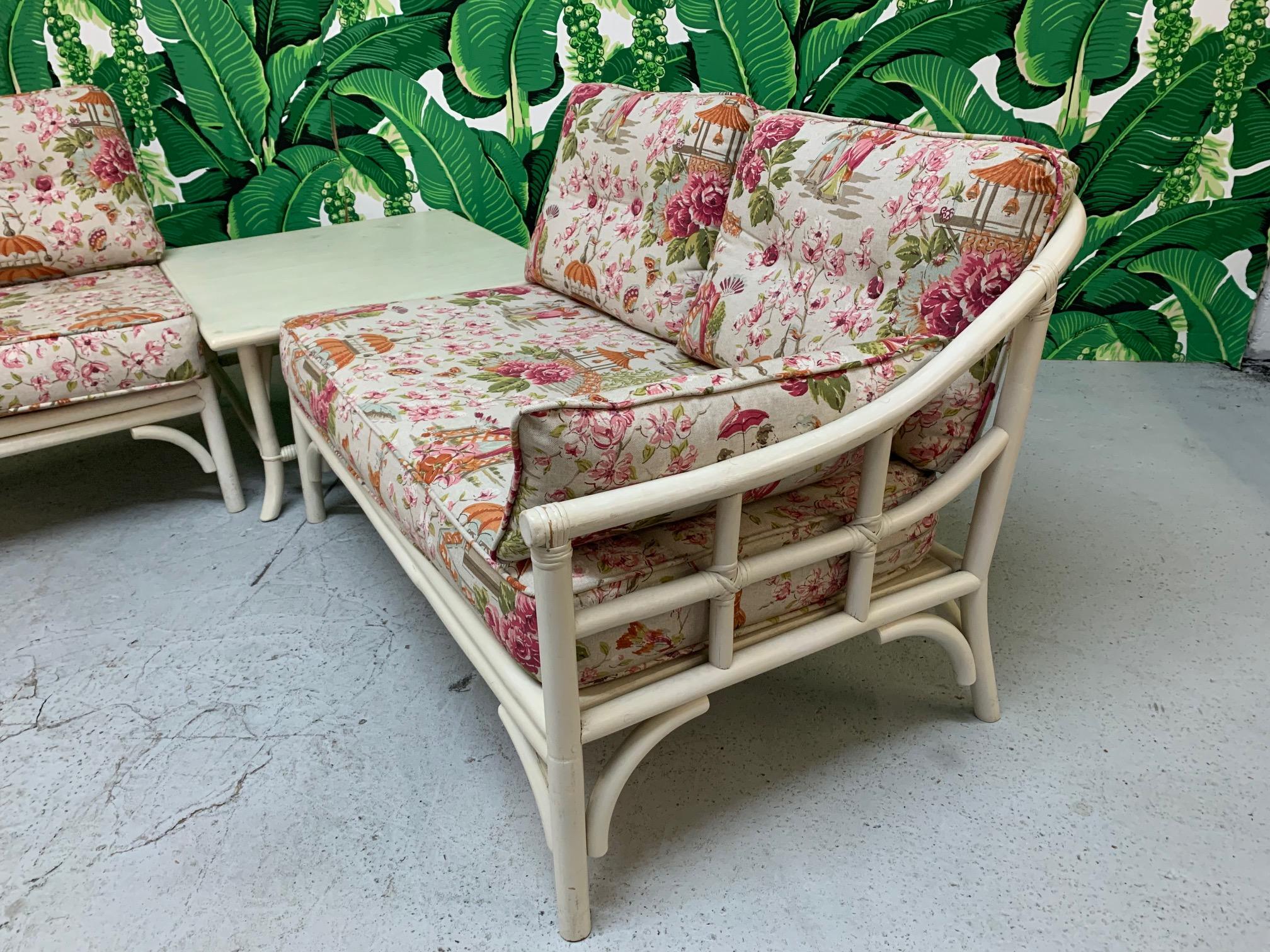 Pair of vintage rattan club chairs newly upholstered in a beautiful Asian chinoiserie print. Chinese scenes with flowers and a neutral background. Excellent condition. Cushions are newly reupholstered and in excellent condition. Finish shows some