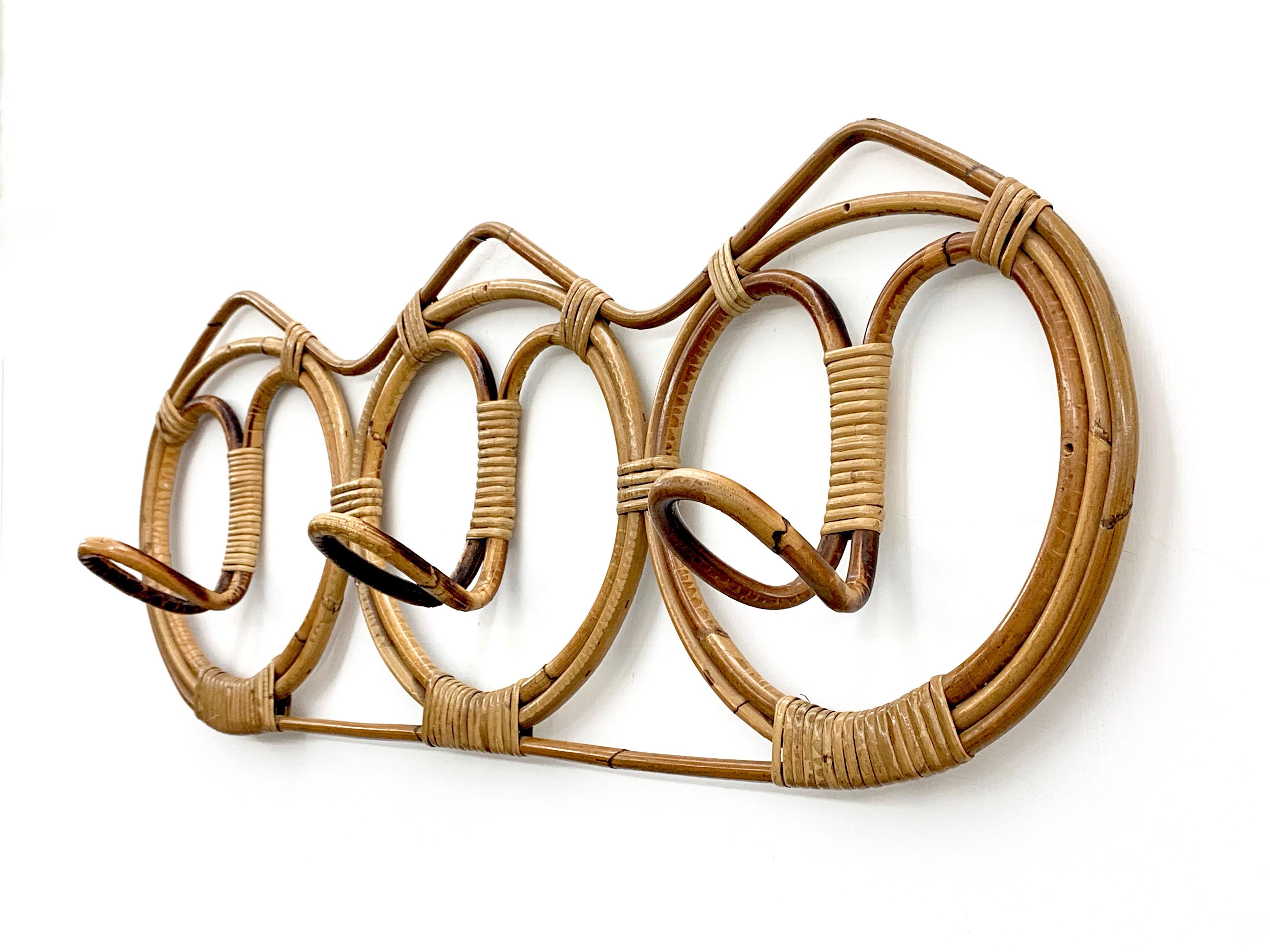 Incredibile appendiabiti di metà secolo in rattan e bambù. Questo splendido pezzo è stato prodotto in Italia negli anni Sessanta.

L'articolo è sorprendente perché presenta un cerchio di bambù e rattan con tre ganci per appendere i