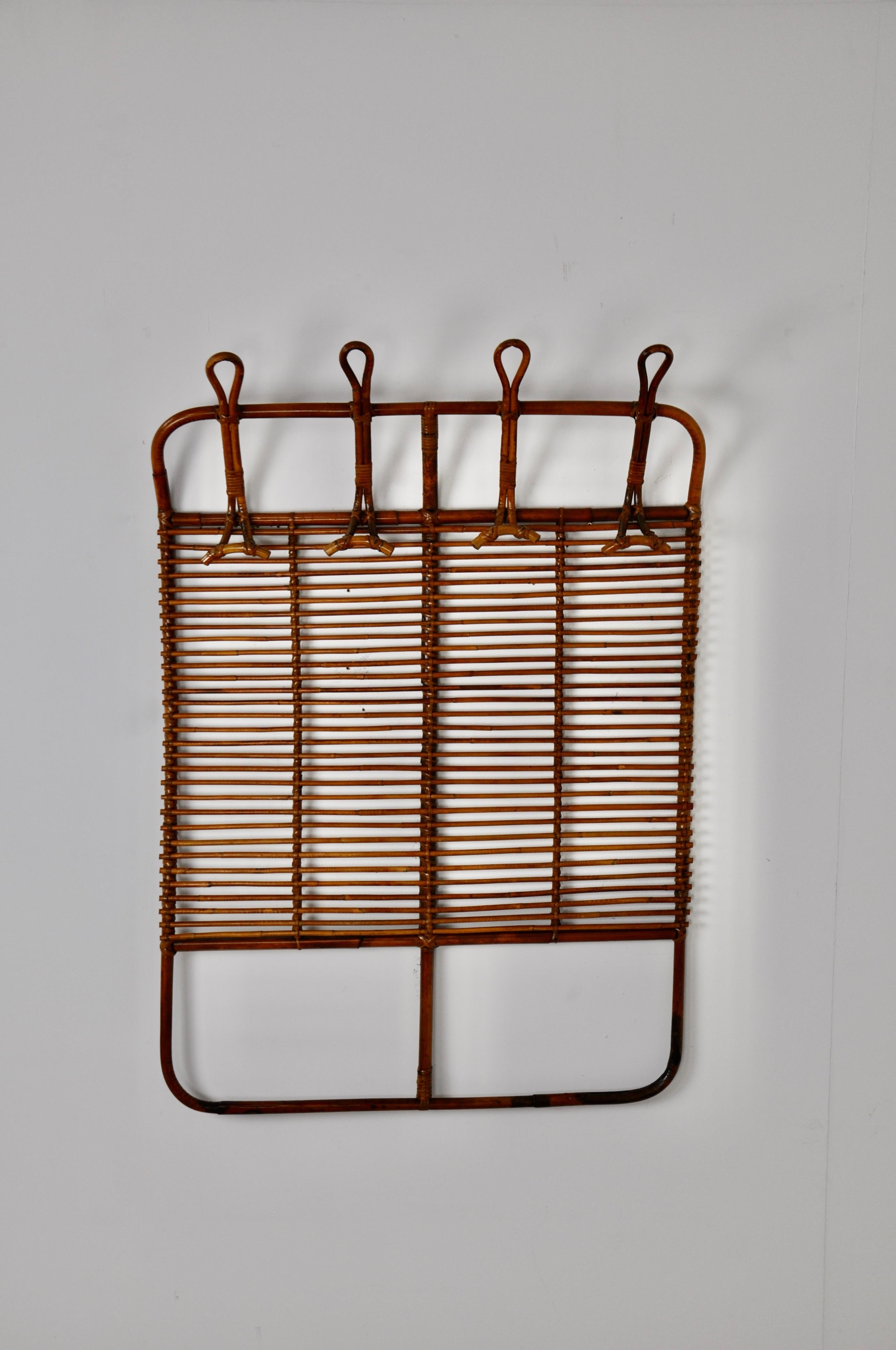 Rattan coat rack composed of 4 hooks. Wear due to time and age of the coat rack.