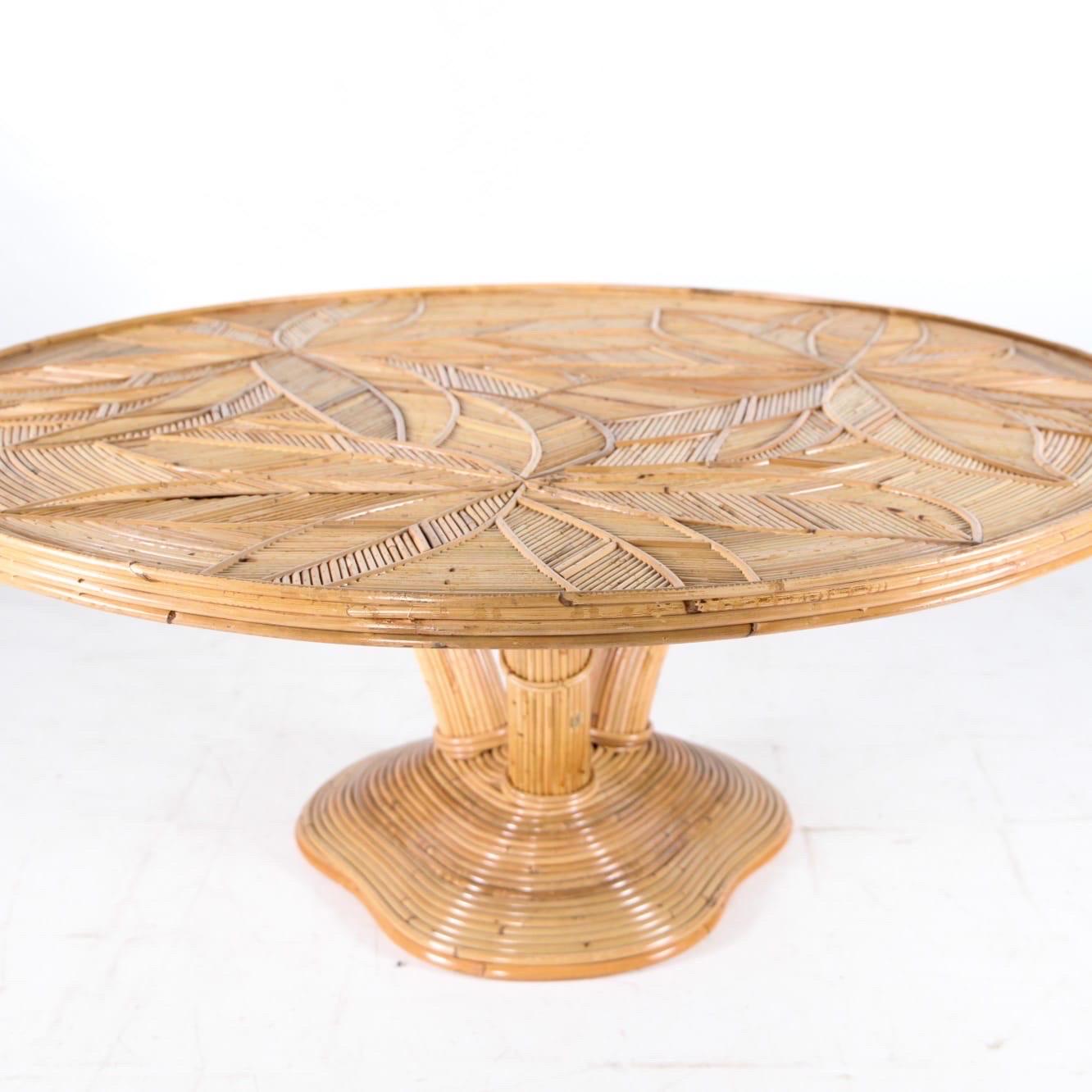 Incredible rattan round coffee table with « palmtrees » patterns.
Three legs representing a palmtree and top with palms patterns covered by a glass top.
Beautiful patina, excellent condition. 