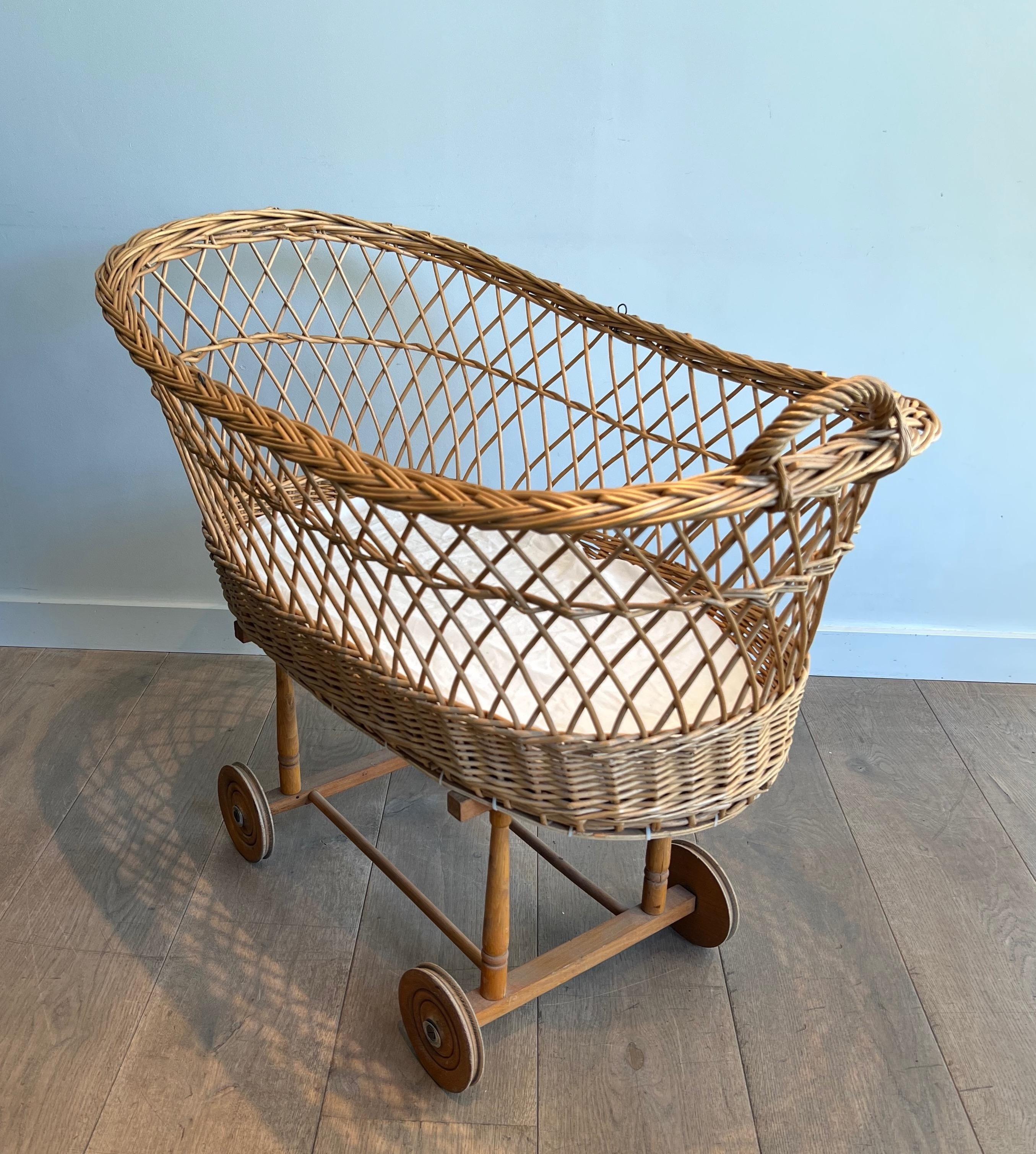 This very nice and uniquel cradle is made of a fine rattan work placed on a wooden base with casters. This is a French work. Circa 1950