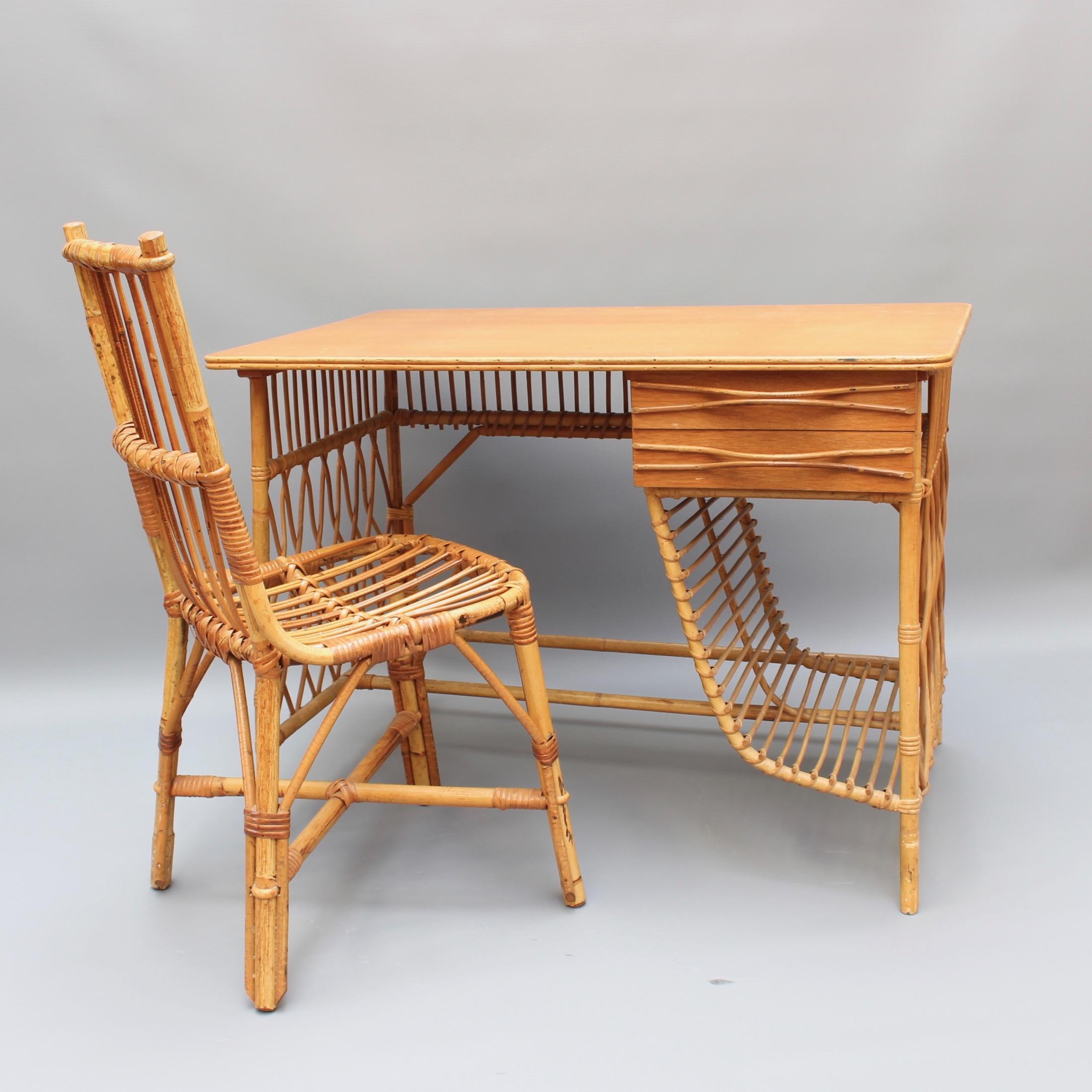 Rattan desk or vanity table and chair set by Louis Sognot (circa 1950s). An absolute charmer and an icon of the era. There are two drawers located under the desk with stylishly curved drawer handles. Underneath, a sensuously designed storage space.