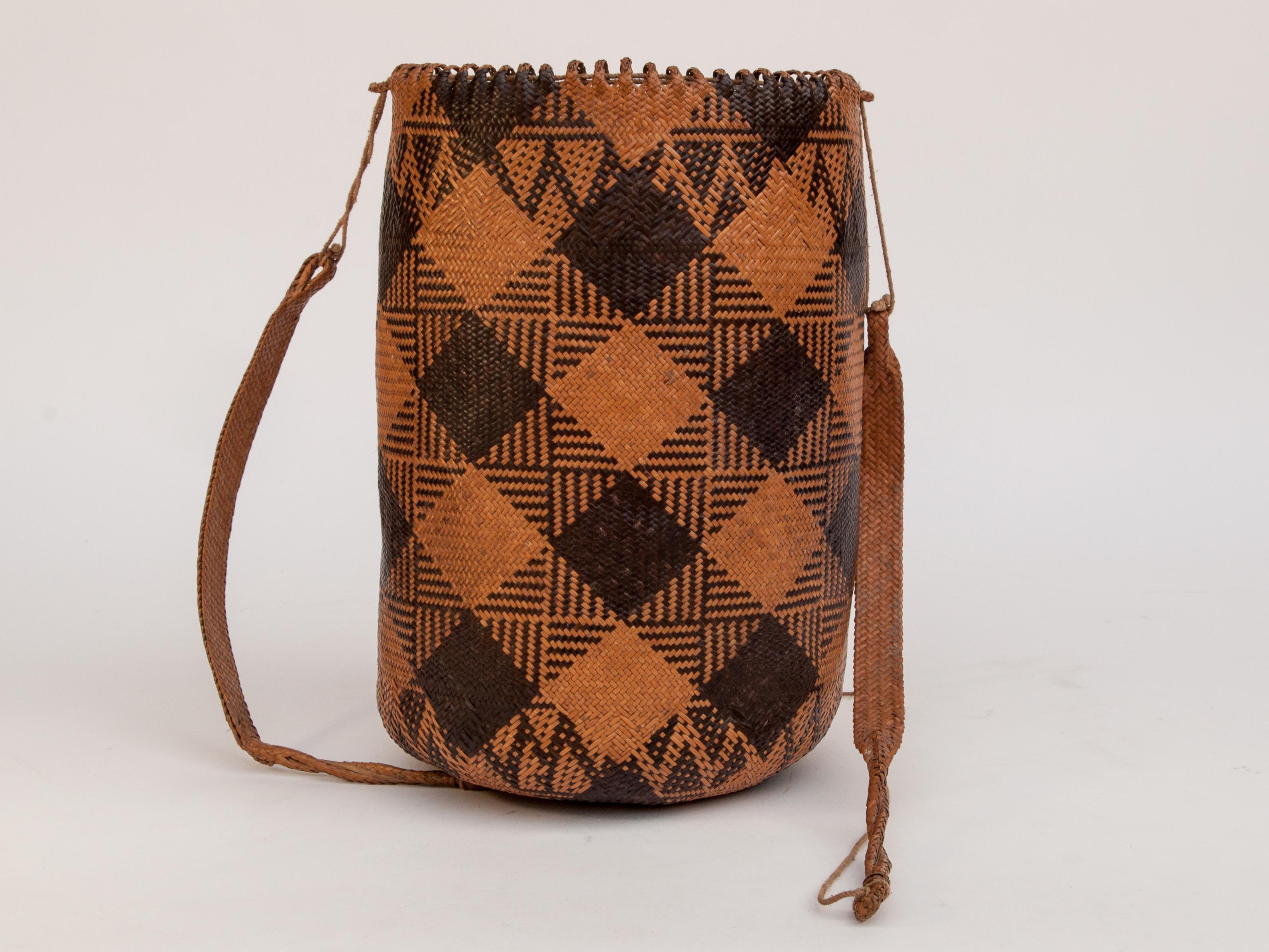 Rattan drawstring shoulder bag basket. Dayak of Borneo, late 20th century.
This thoroughly utilitarian shoulder basket comes from the Dayak of Borneo. Very cleanly woven of rattan with a geometric design, it is pliable and extremely durable. The