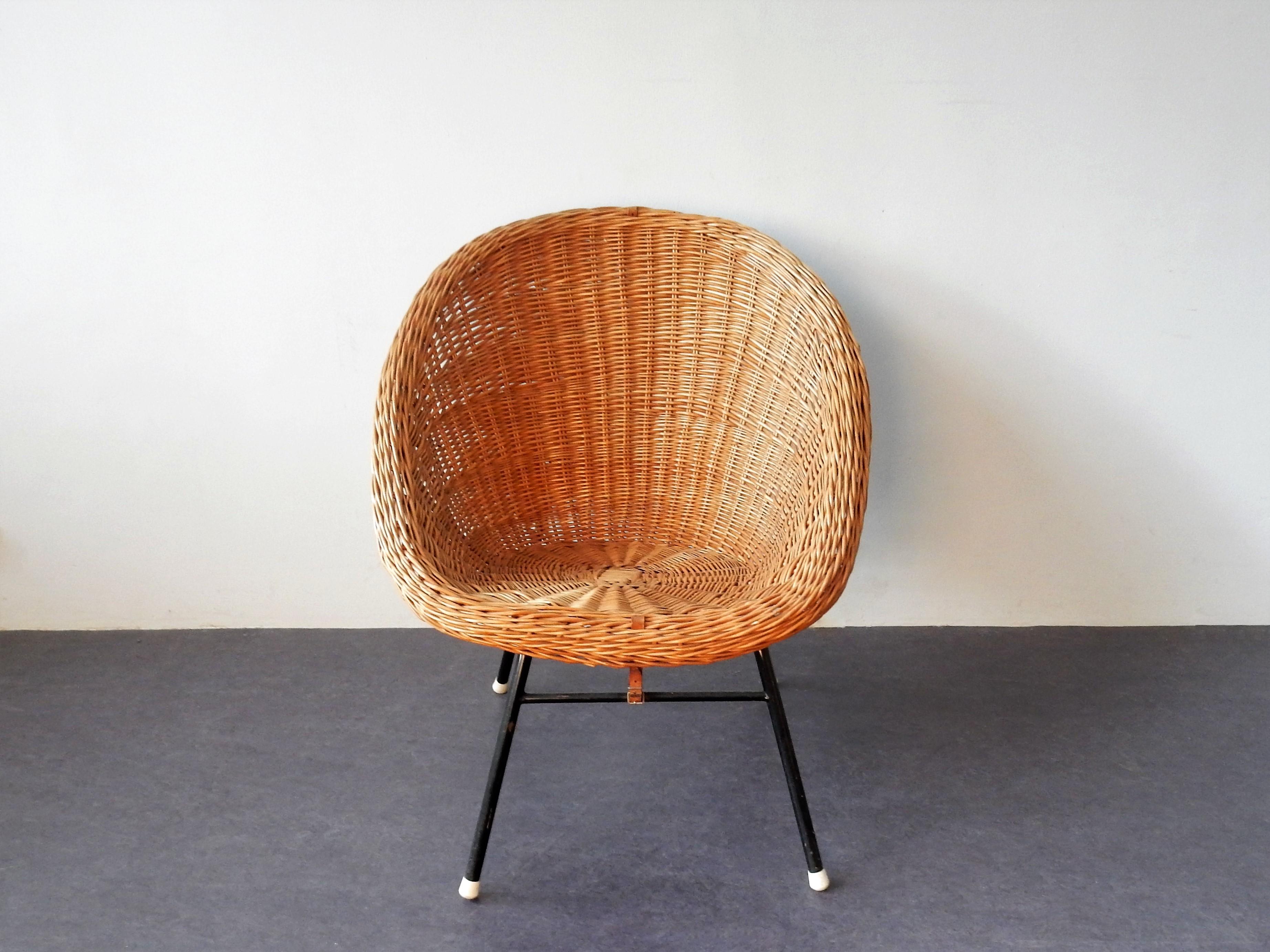 This elegant rattan easy chair is very much in style of the designs by Dirk Van Sliedrecht for Rohe Noordwolde in the Netherlands. It has a black metal frame and a comfortable rattan seat, which is connected to the frame by 2 brown leather belts,