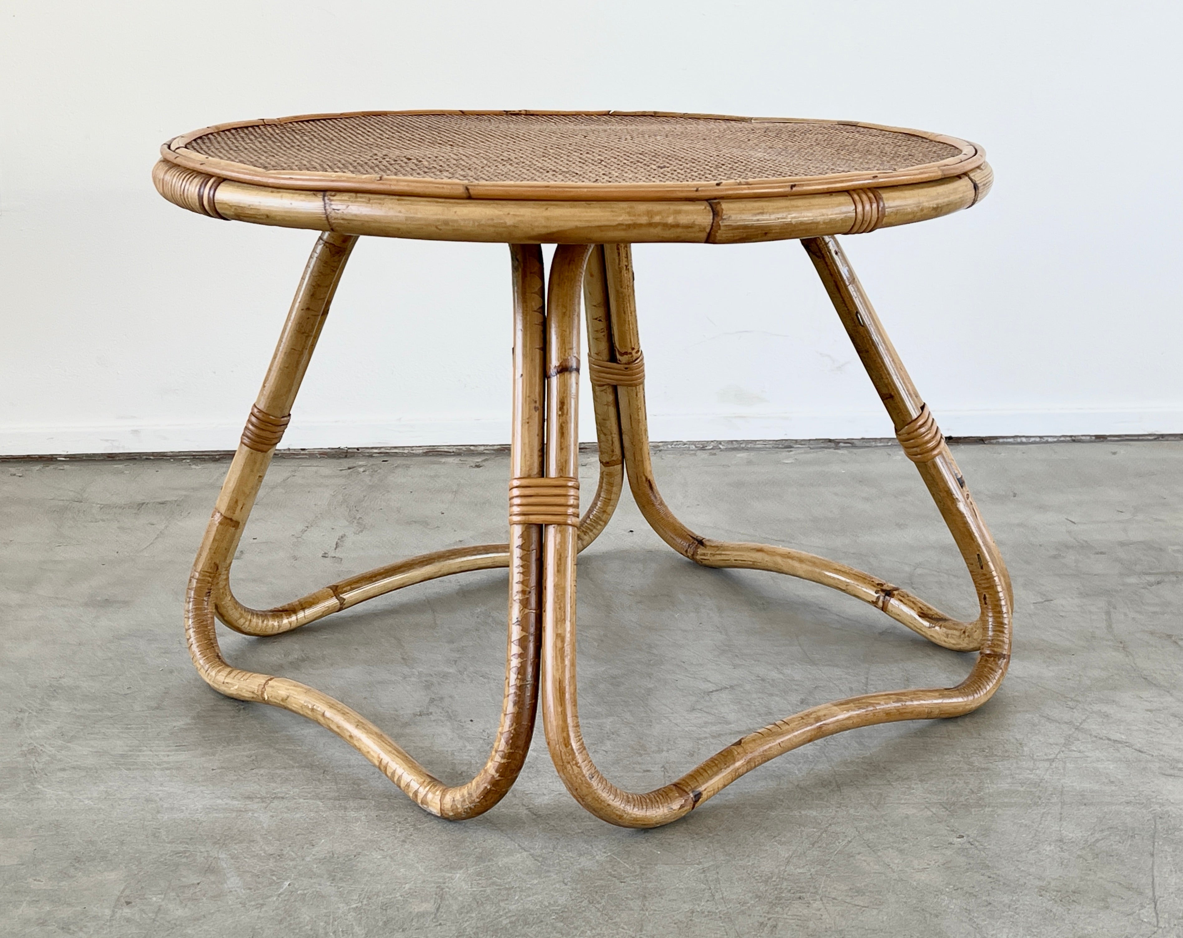 Round Italian bamboo and wicker coffee table with sculptural base and unique woven wicker top.