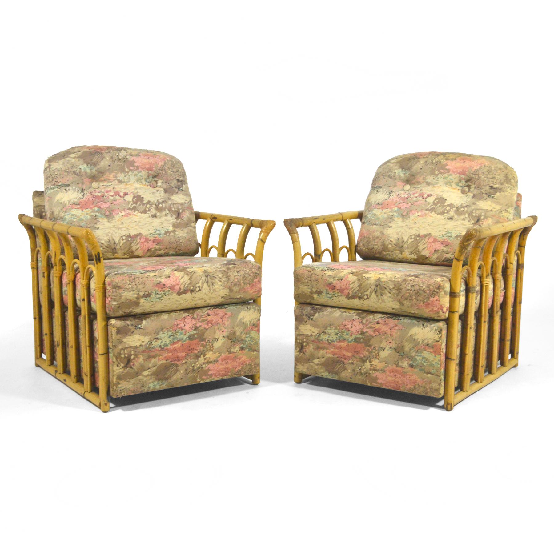 This pair of tropical club chairs from the late 40s/ early 50s have external arms which frame the upholstered bodies in natural rattan and add a curved flair.