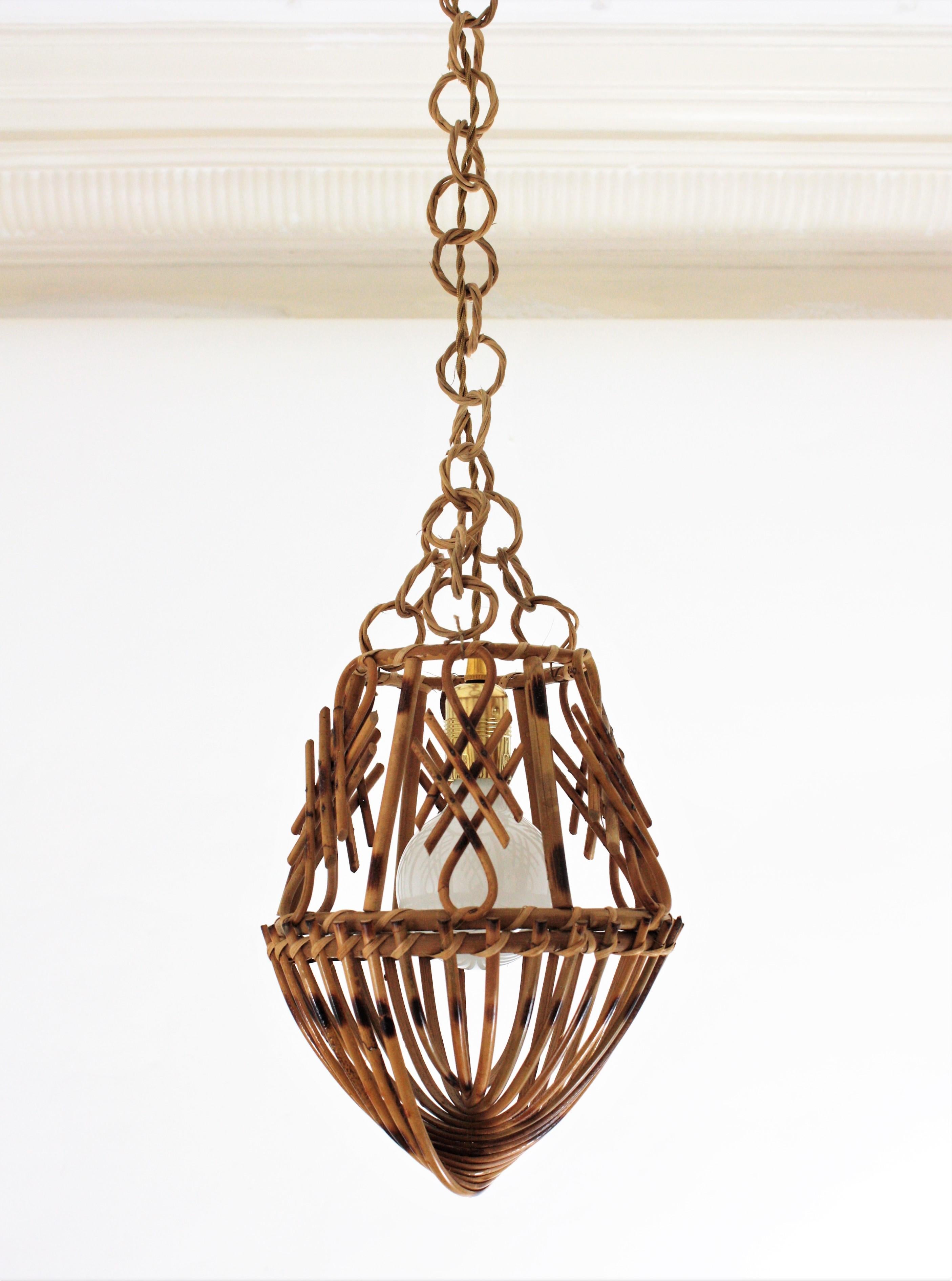 Rare midcentury chinoiserie style handcrafted rattan and wicker pendant lamp. France, 1950s.
This lantern is all made by hand with rattan canes. The shade is comprised by a rattan structure with chinoserie decorations and a twisted bottom made with