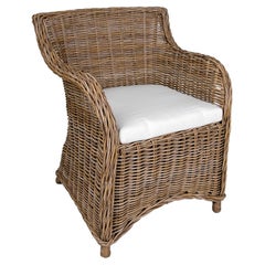 Chaise de jardin en rotin avec coussin dans les tons grisâtres