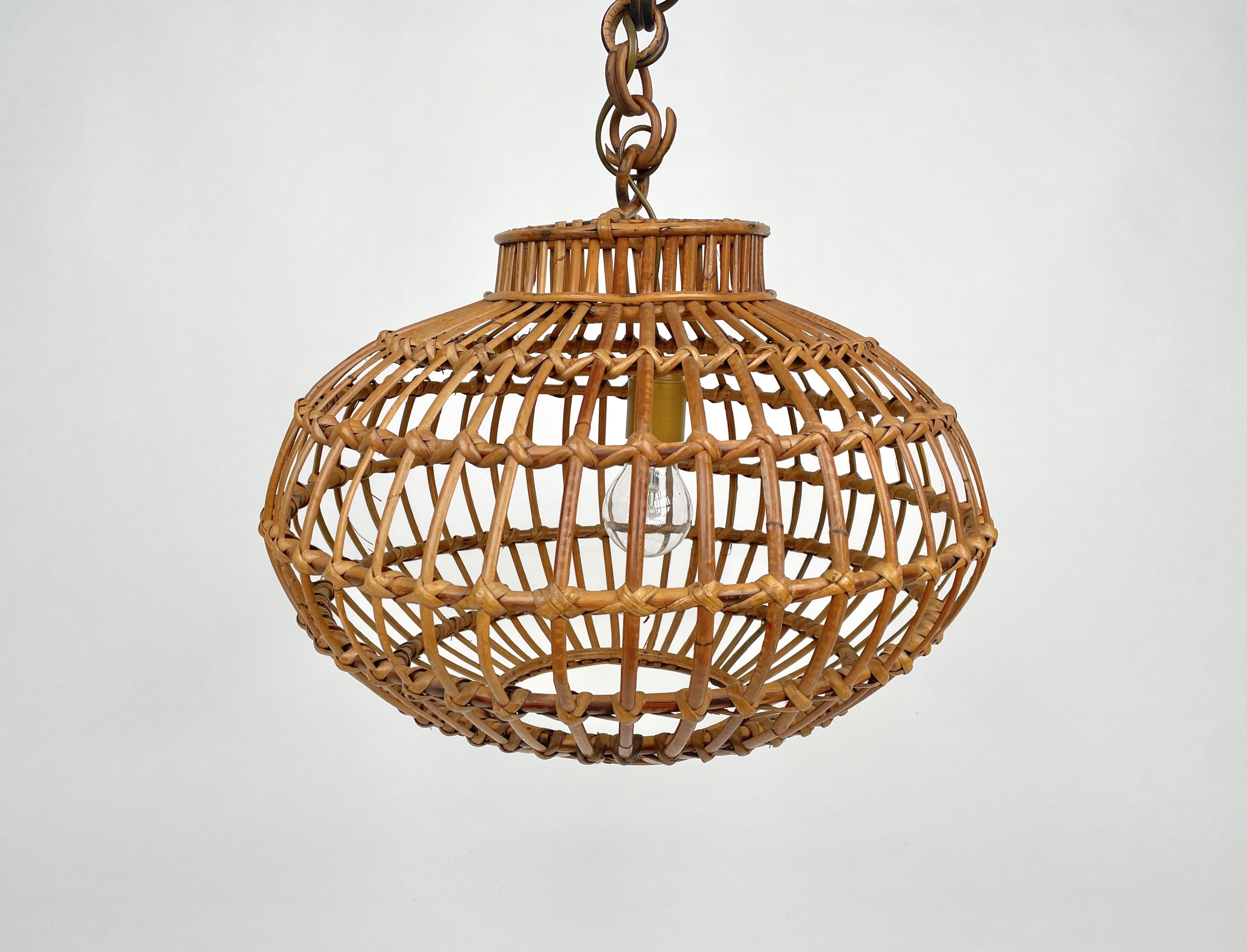 Italy Modern rattan lantern with globe or ball shaped lampshade. Made in Italy in the 1960s.
This suspension lamp is entirely handcrafted with rattan. The ball shaped shade hangs from a chain with round rattan links which can be shortened to adjust