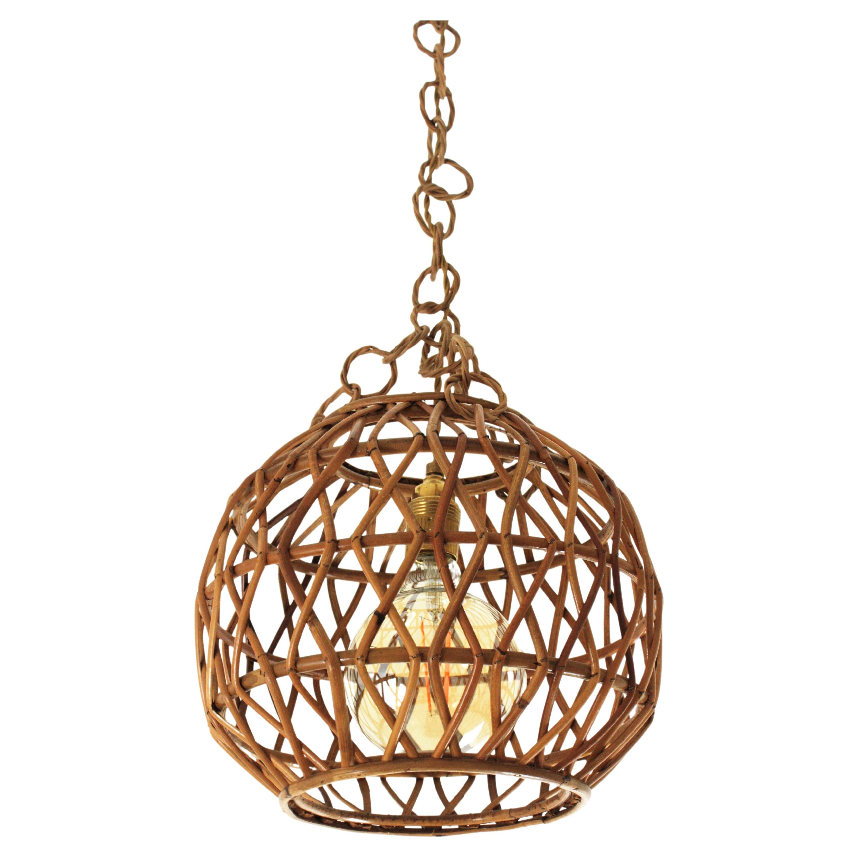 Mid-Century Modern rattan ball shaped lantern or pendant ceiling lamp. Italy, 1950s-1960s.
This suspension features an spherical lampshade made of double twist rattan canes. It hangs from a chain with wicker links topped by a brass canopy. The