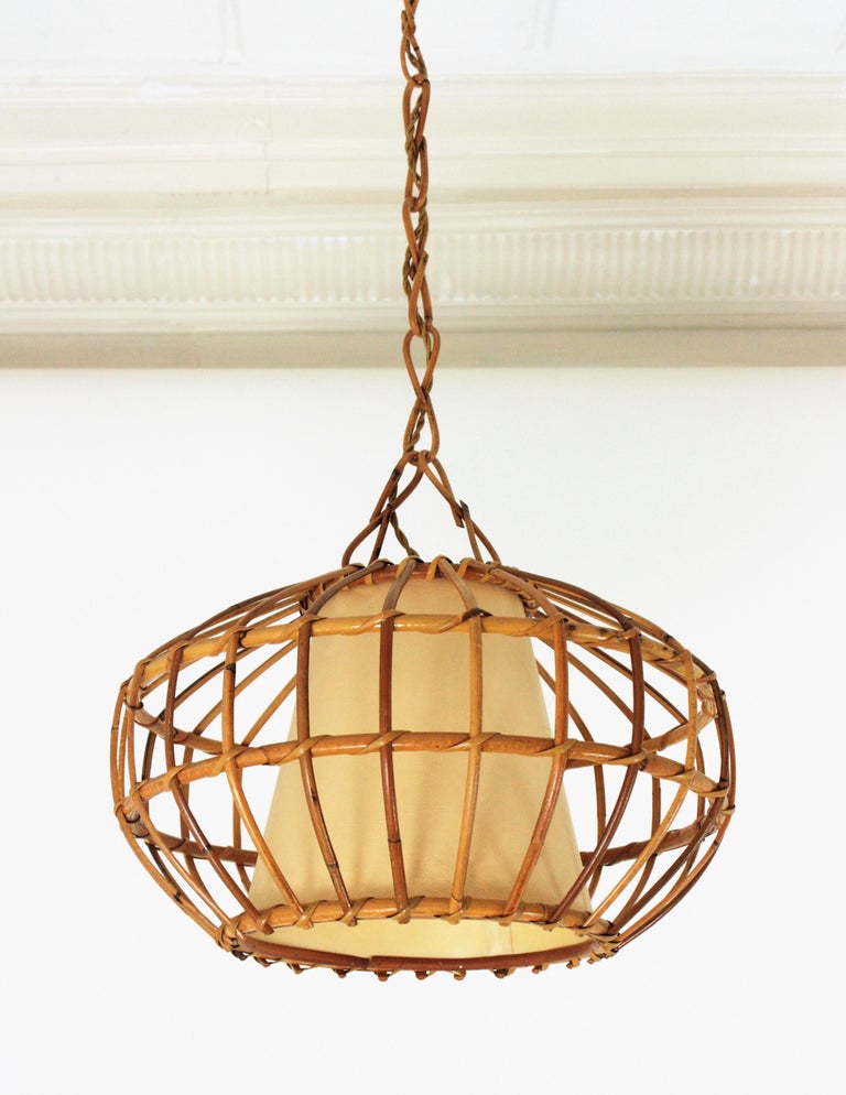 A cool handcrafted rattan large ceiling pendant hanging light with inner paper shade, Spain, 1960s.
This large lantern has an eye-catching design featuring a globe shaped rattan structure with a conical paper lampshade at the interior part to