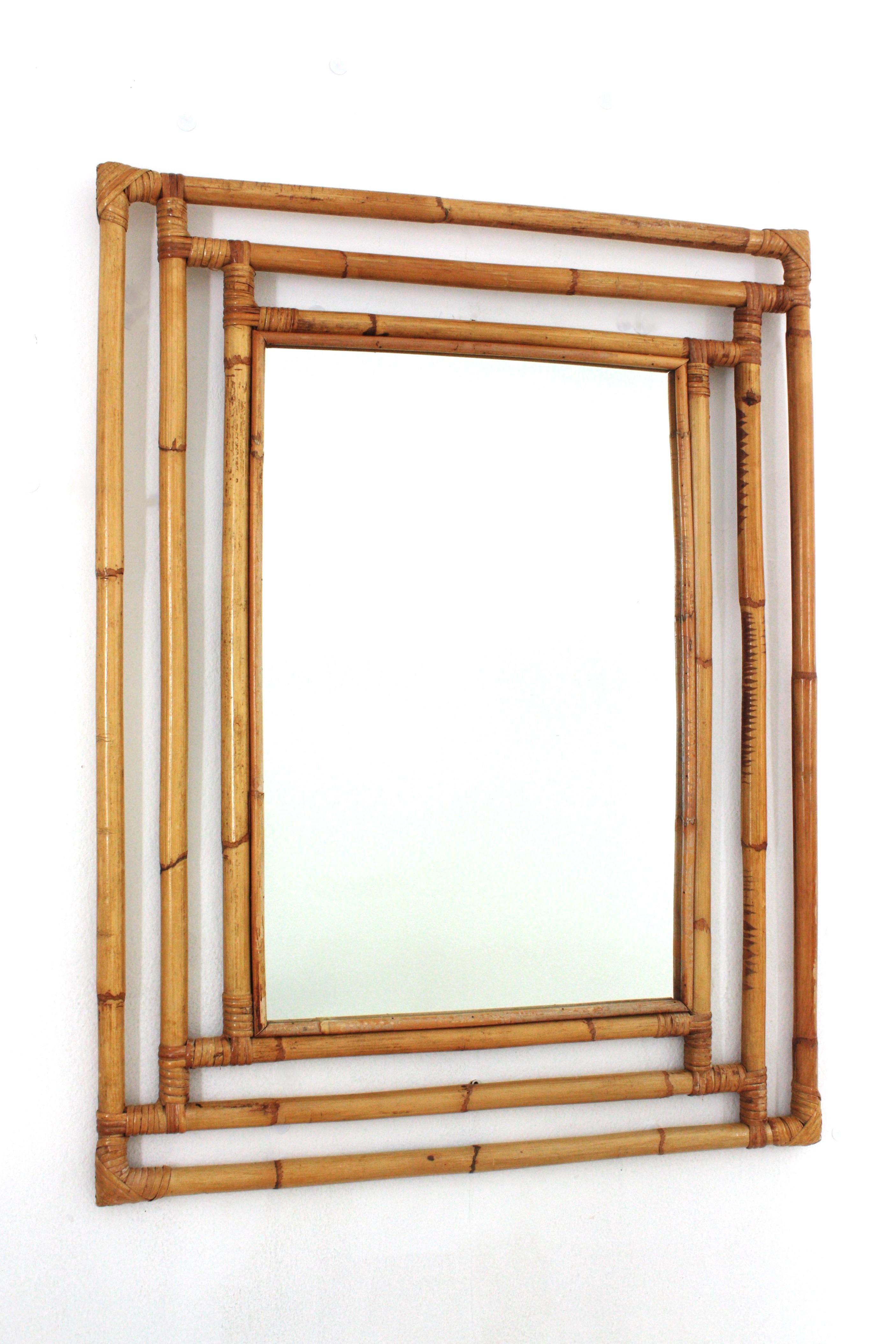 Espejo de pared de ratán español de mediados del siglo XX
Precioso espejo rectangular de estilo Tiki hecho a mano con caña de bambú. España, años 60.
Marco de bambú artesanal muy decorativo con formas geométricas, acentos orientales y una gran