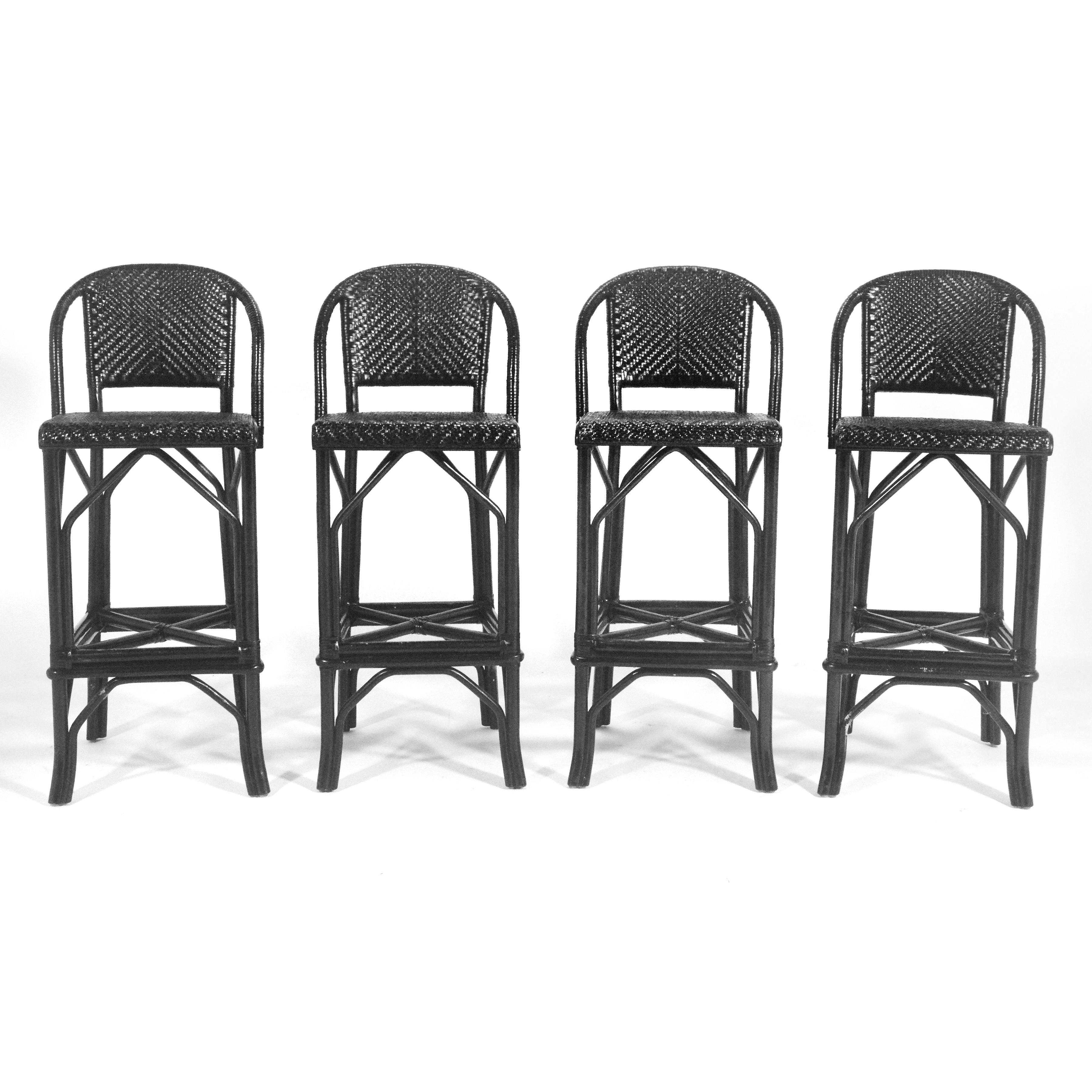 These striking and well made stools, likely by Brown Jordan, have frames of rattan that have leather bindings at the joints and woven leather seats and backs. Finished in black, they have a strong graphic presence.