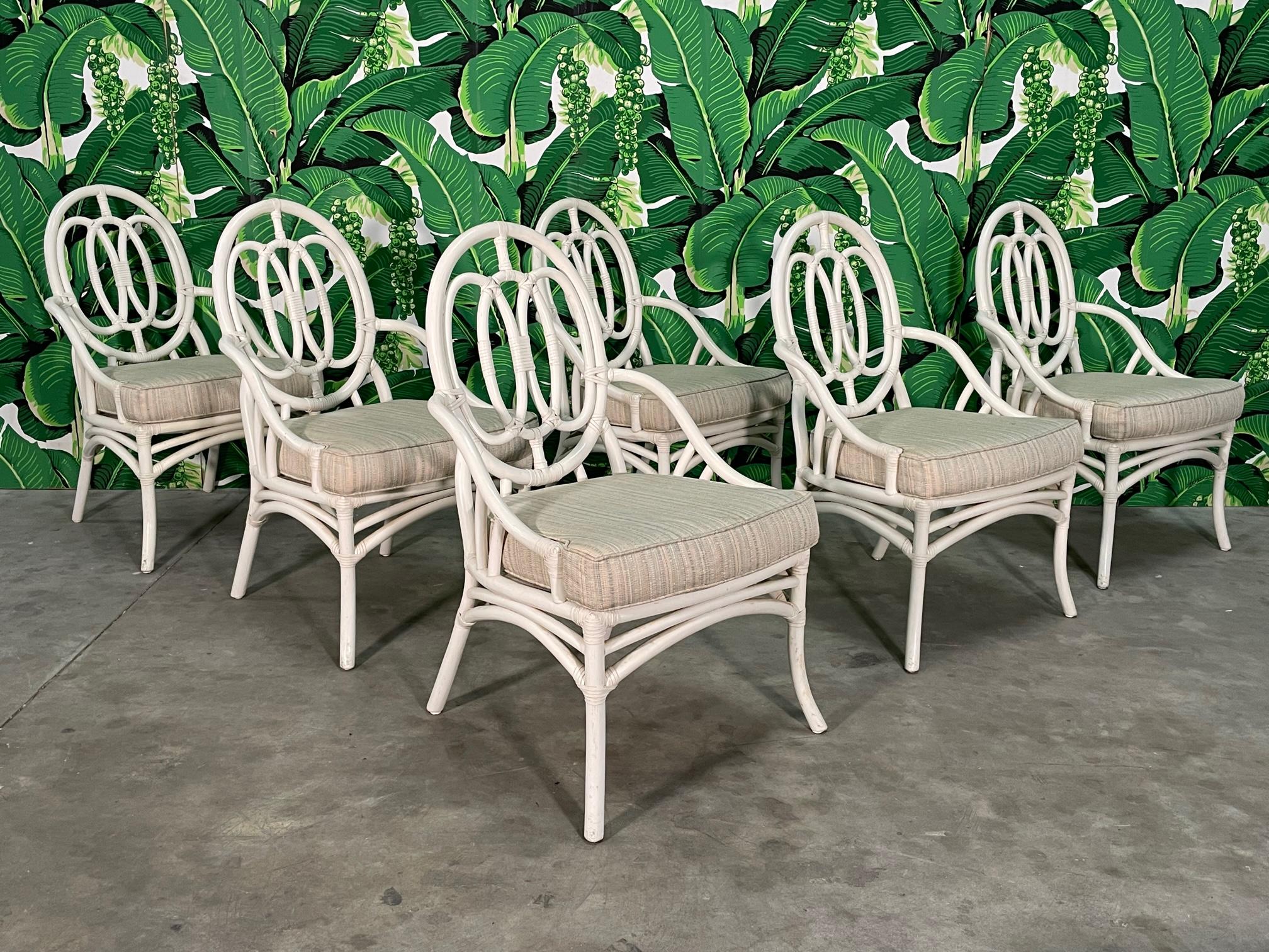 Set of 6 rattan dining chairs by Ficks Reed feature a loop back design, splayed legs, and comfortable upholstered cushions. Good condition with imperfections consistent with age, see photos for condition details.
 
 