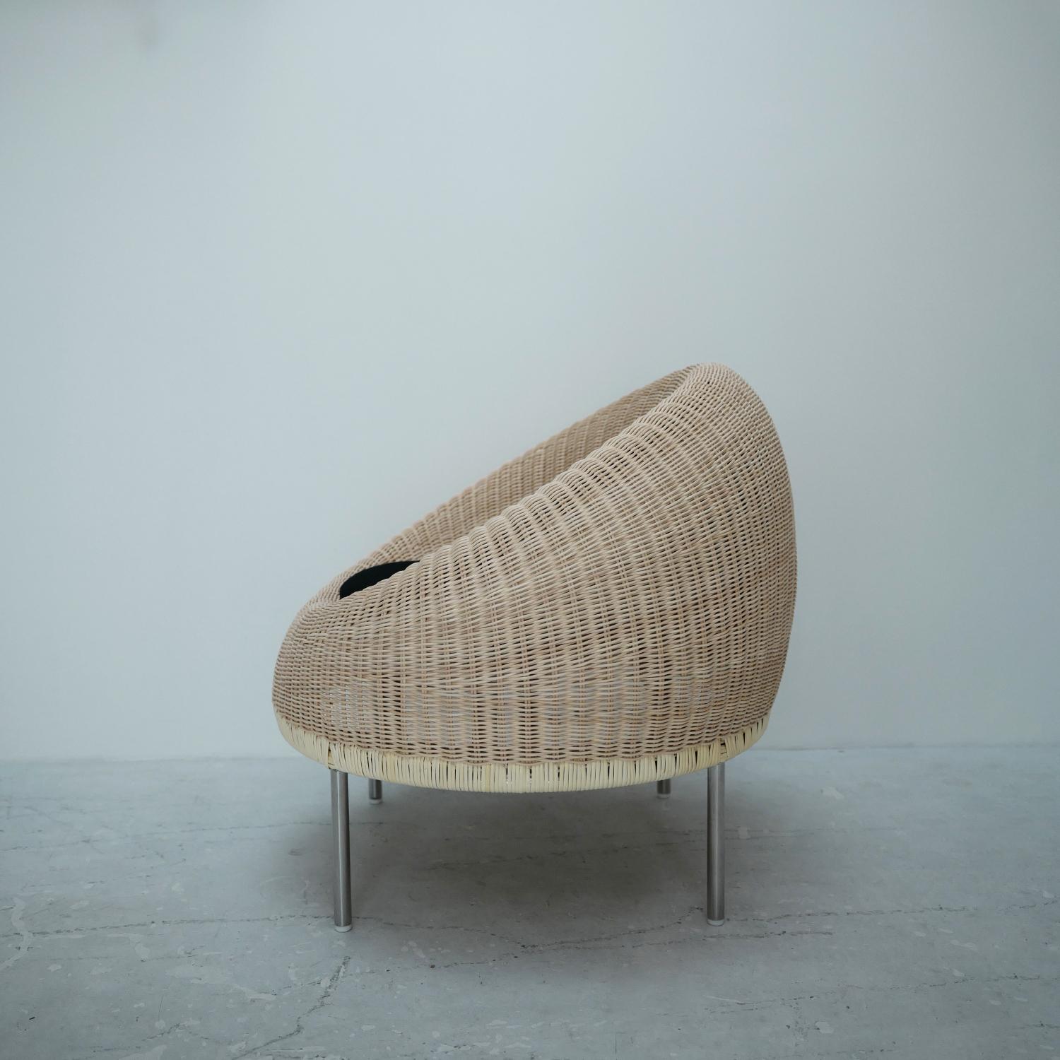 This lounge chair was introduced by Isamu Kenmochi Design Laboratory in 1960. It was designed for installation at the Otone Country Club in Japan. It is a rare piece among Isamu Kenmochi's signature rattan series, in which iron is used for the legs.