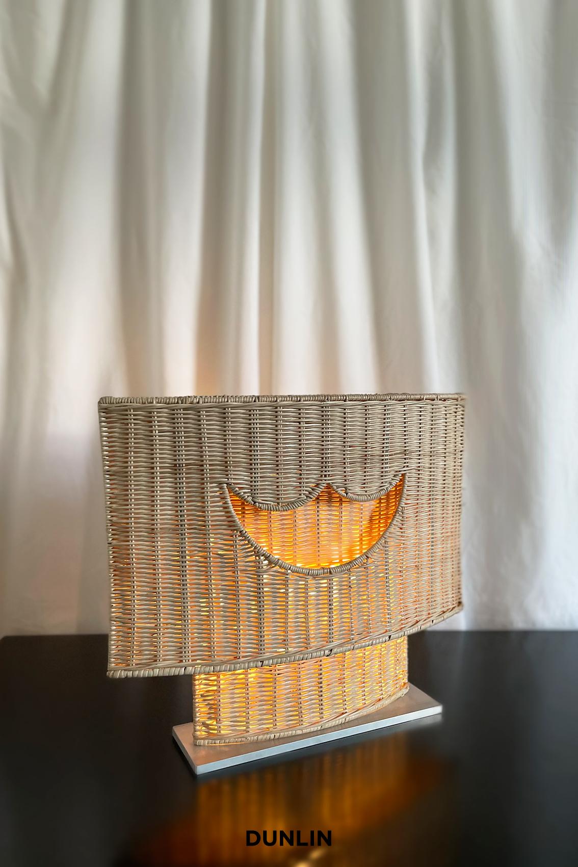 This item was originally an Exclusive style which quickly sold out. We are now happy to offer this style as a Custom Made To Order piece.

The Dunlin Rattan Braided Table Light, radiating a warm and inviting glow to enhance the ambiance of any