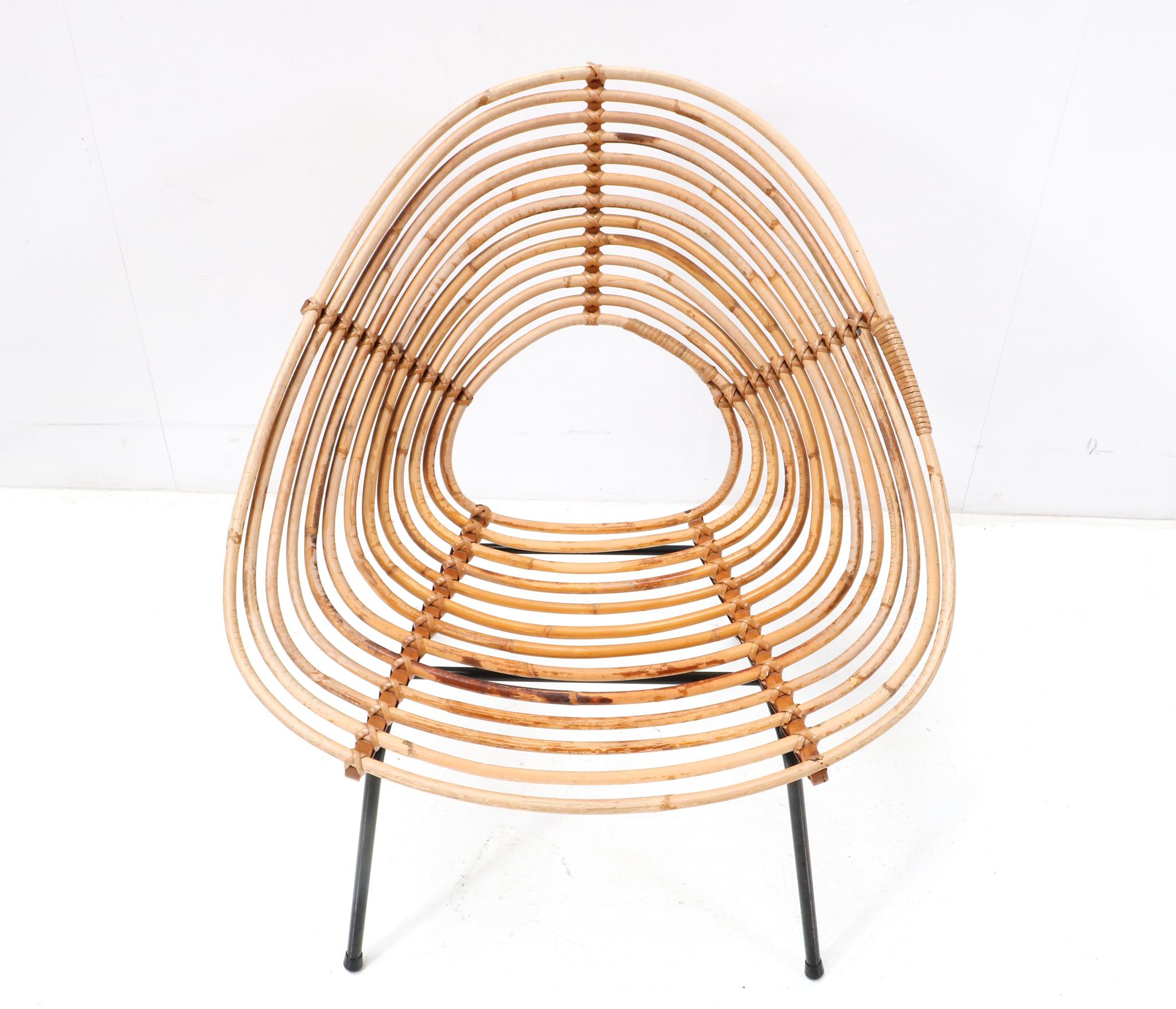 Amazing and rare Mid-Century Modern lounge chair.
Design by Dirk van Sliedregt for Rohe Noordwolde.
Striking Dutch design from the 1950s.
Elegant ballon shaped rattan frame on black lacquered metal feet.
This wonderful Mid-Century Modern lounge
