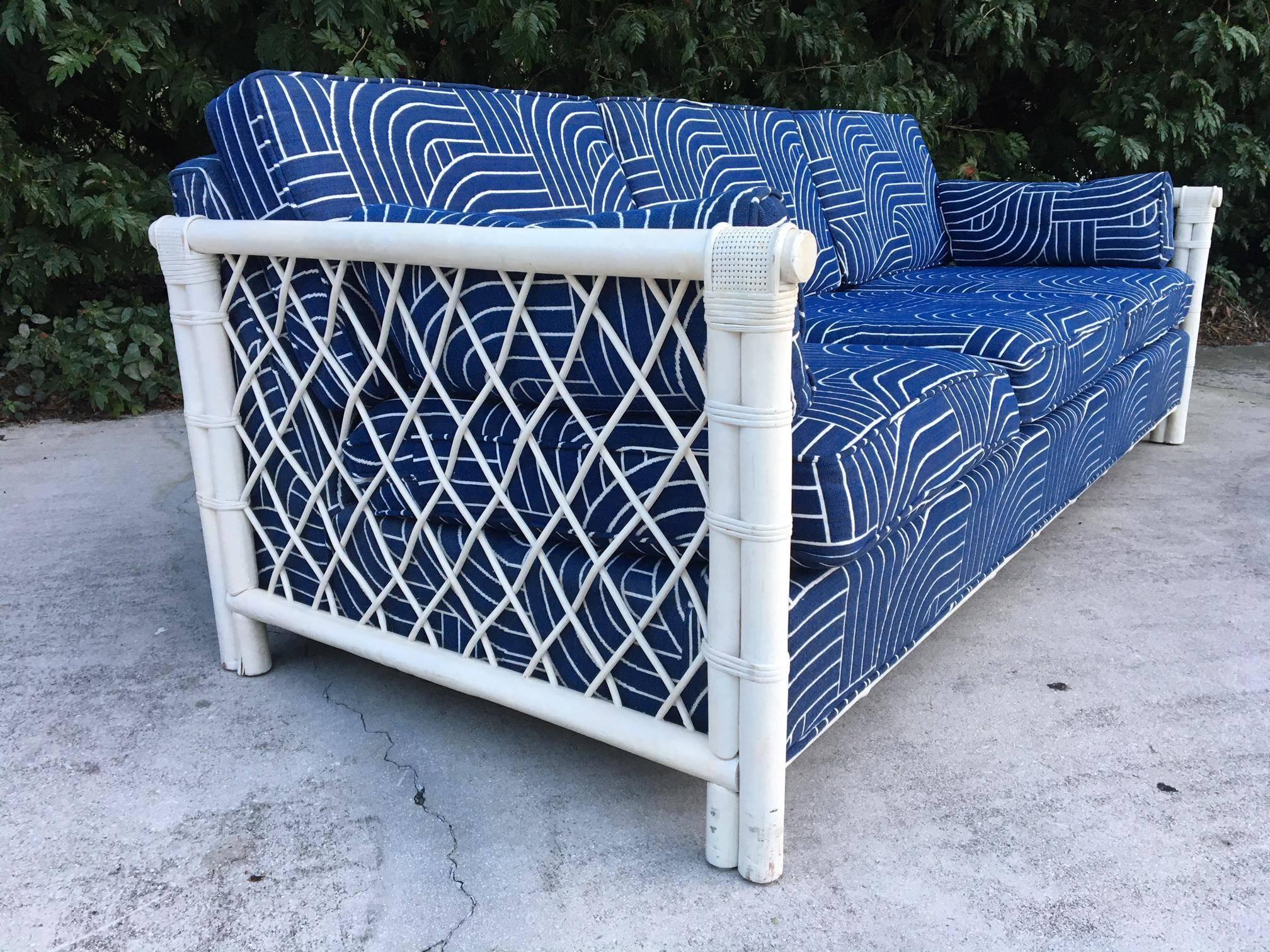 Beautiful rattan sofa features deep blue fabric with a modern print and woven rattan sides. Excellent condition with no stains or tears to fabric, and only very minor signs of age appropriate wear to frame.
Seat height is 17