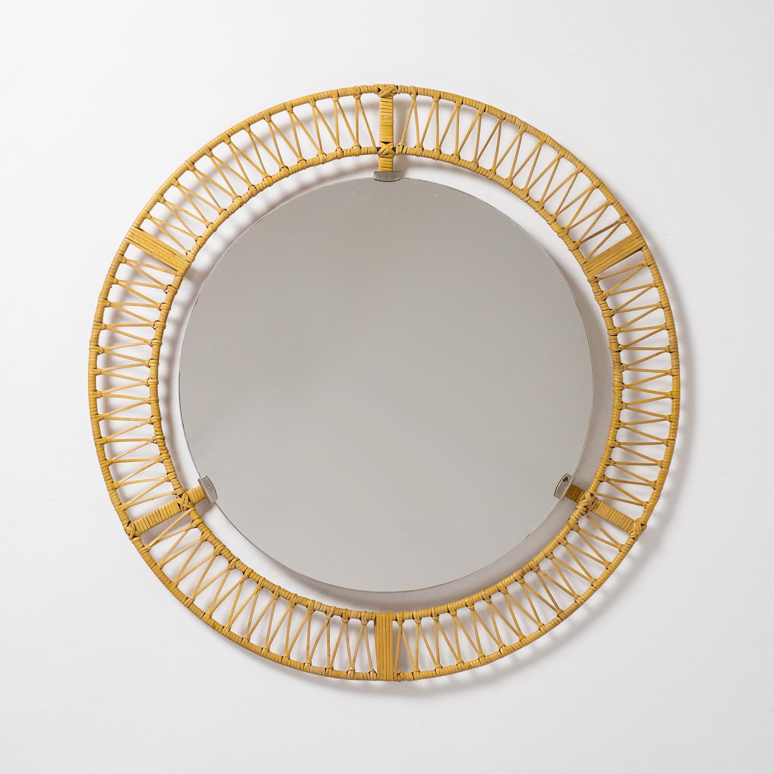 Rare midcentury rattan mirror, circa 1960. Two concentric steel 'circles' wrapped and woven with rattan or wicker. The original mirror is held by three nickeled brackets in a floating manner. Fine original condition with patina on the metal parts.