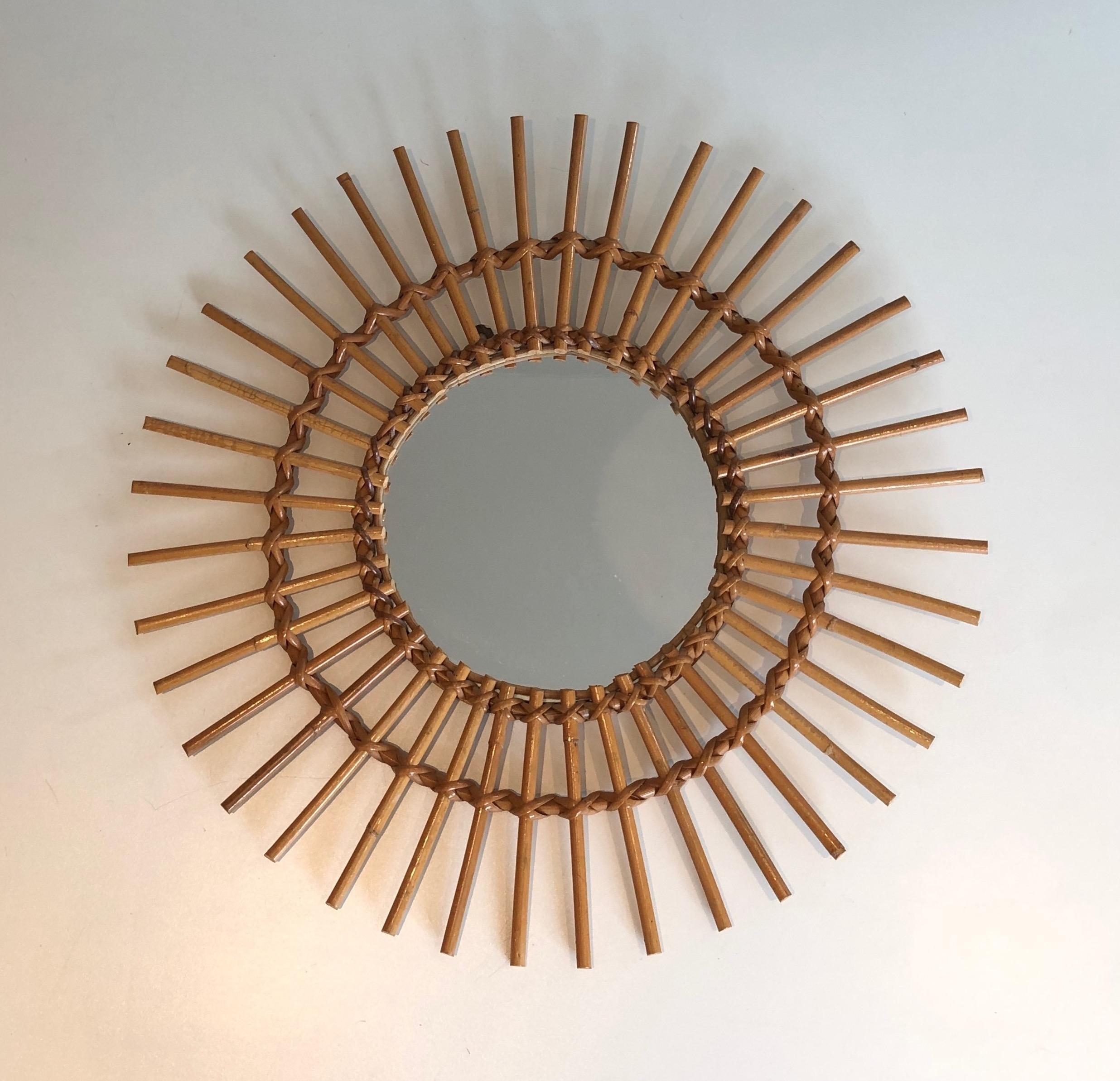 This round mirror is made of rattan, This is a French work, circa 1970.